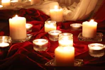 Several lit candles on a red cloth