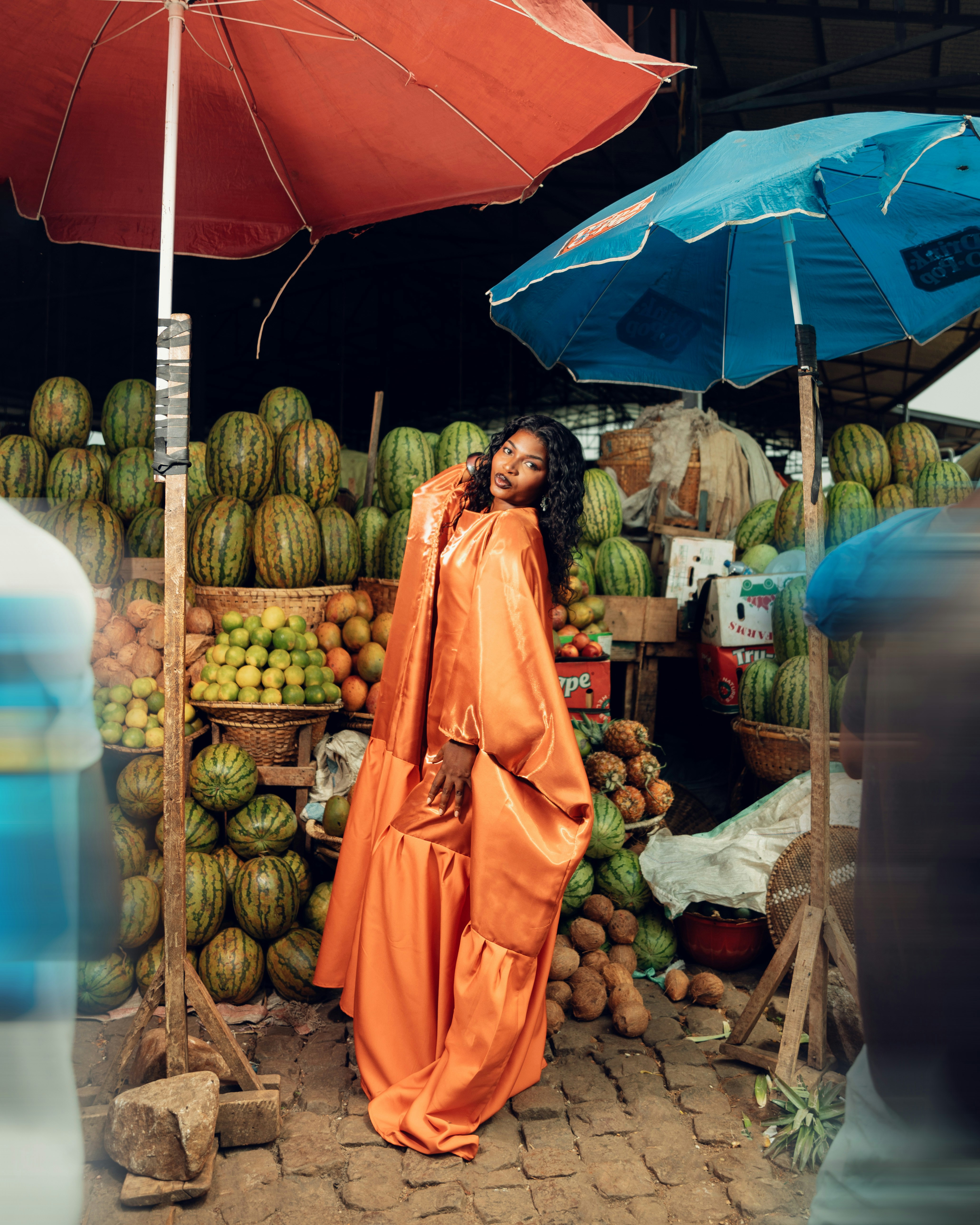 Woman in orange dress at a fruit market