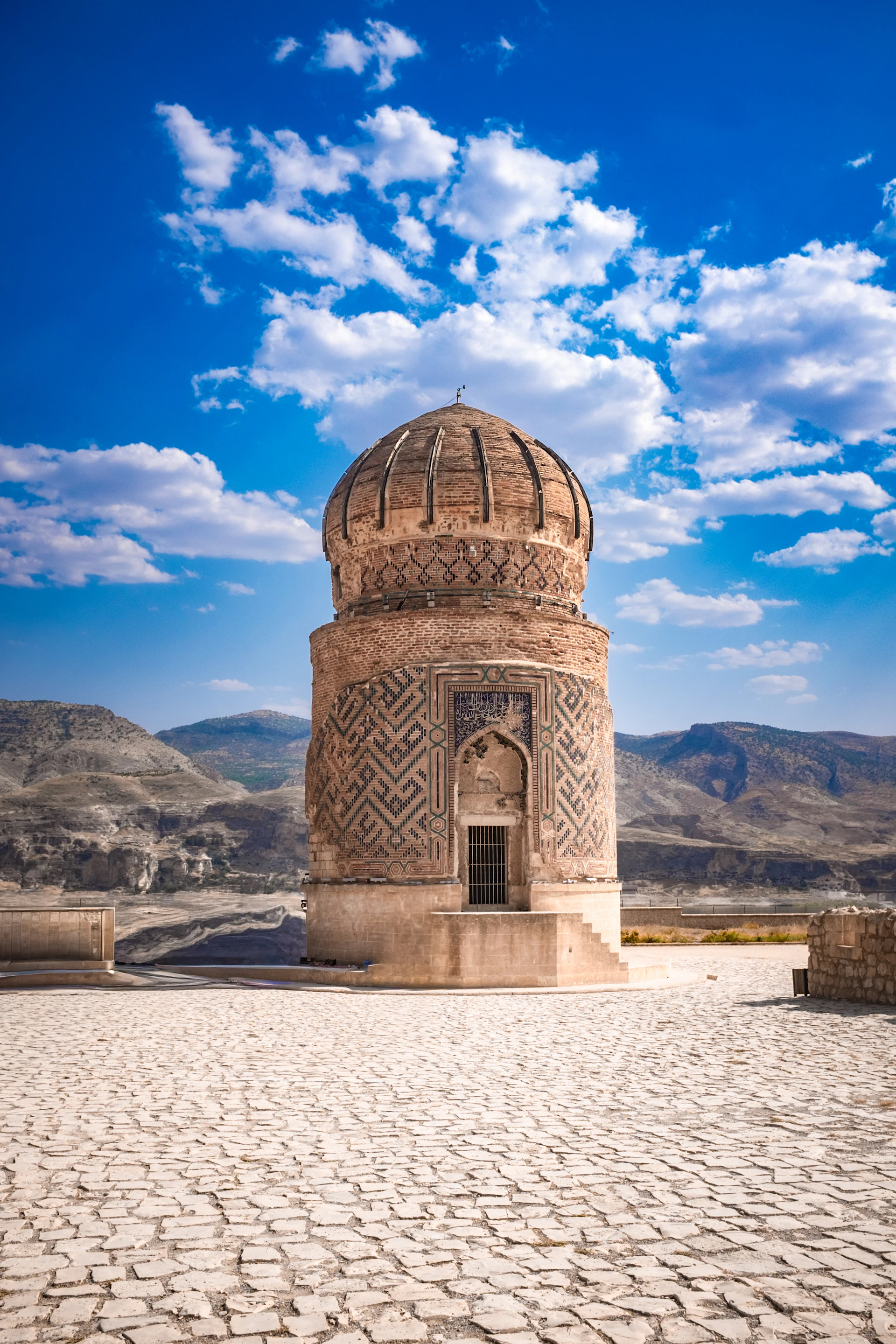 Ancient stone tomb with patterned walls under blue sky