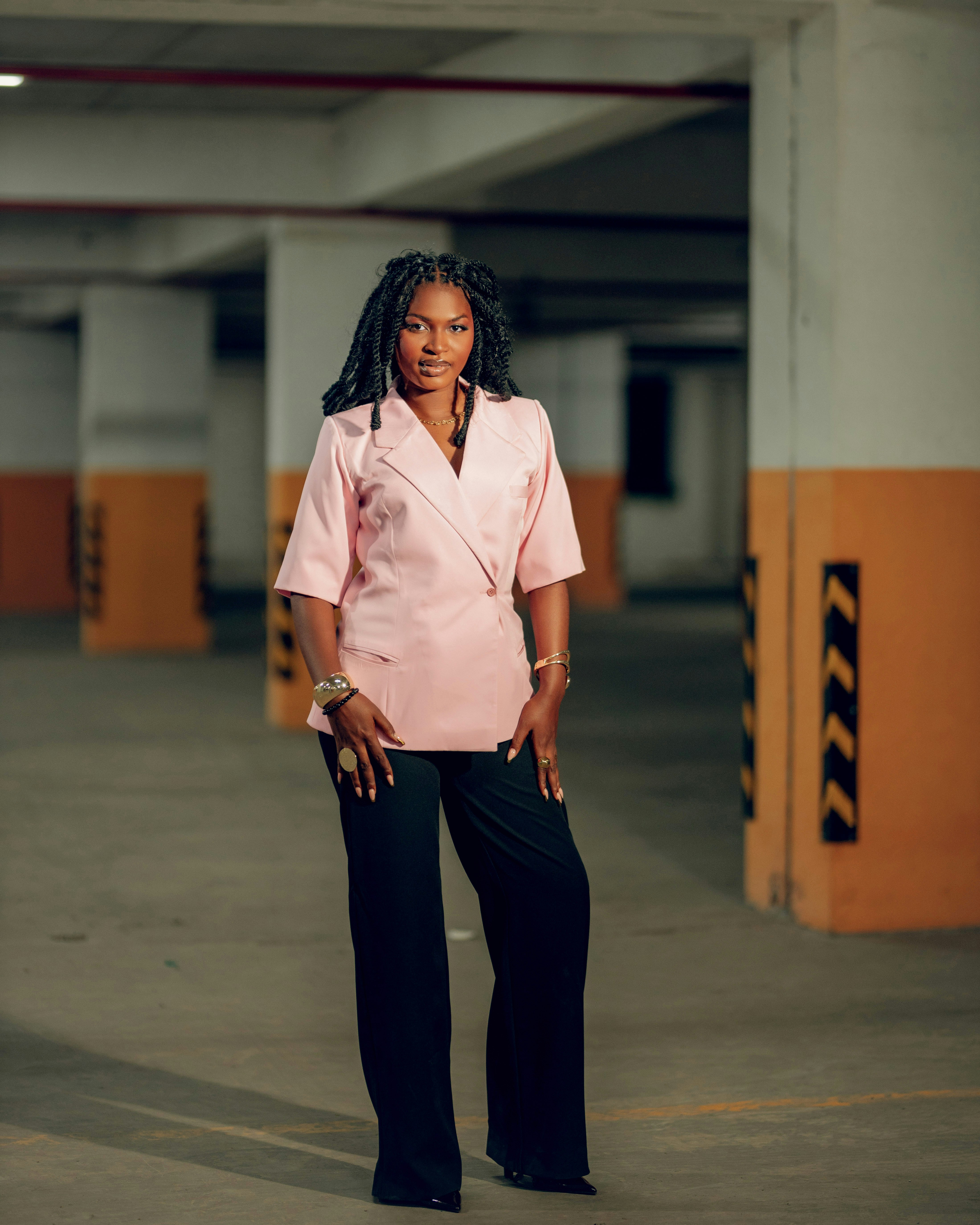 Une femme se tient dans un parking.