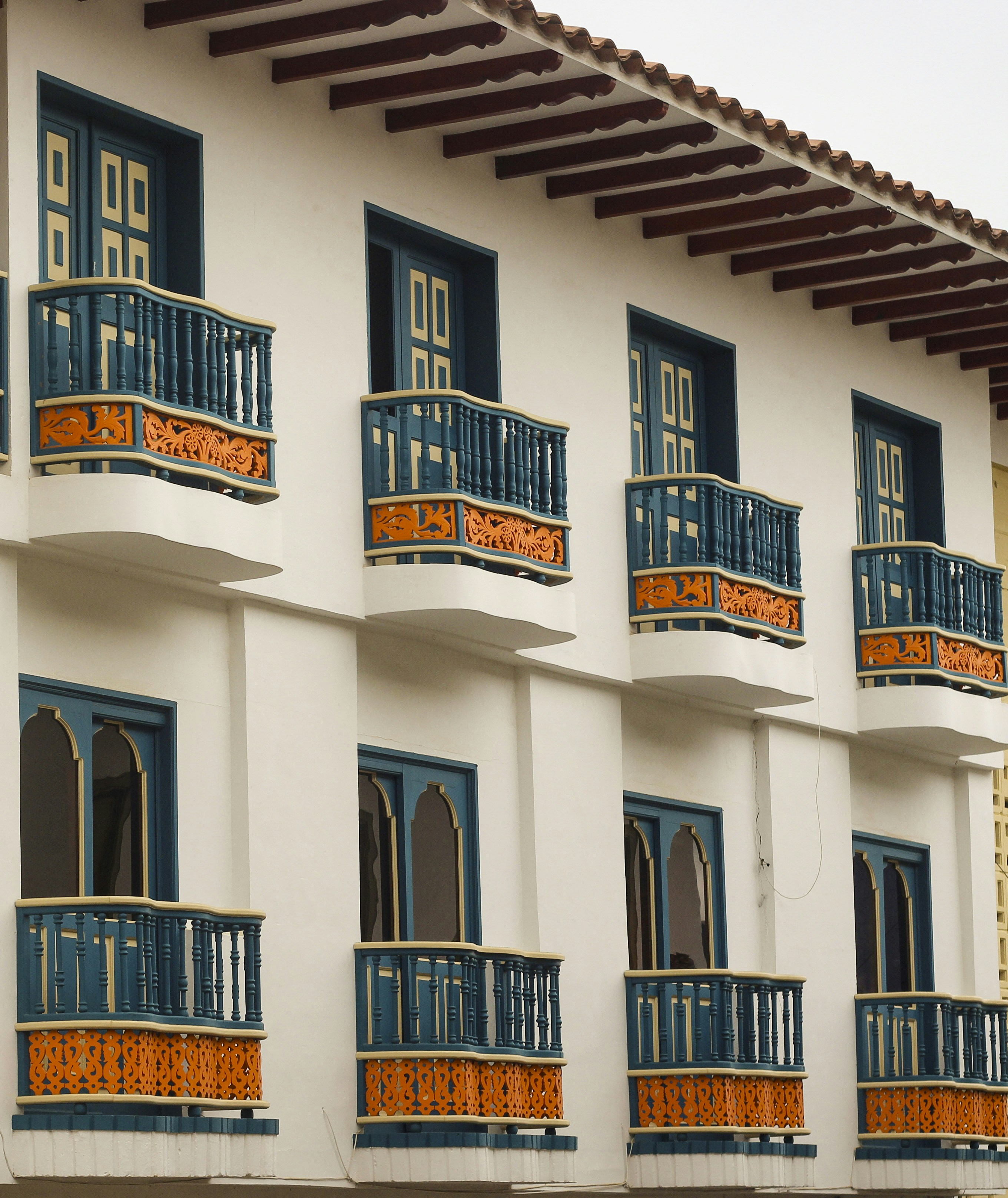Edificio bianco con balconi e finestre colorate.