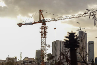 A construction crane towers over city buildings.