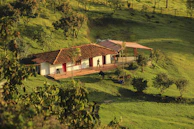 Farmhouse nestled on a lush green hillside.