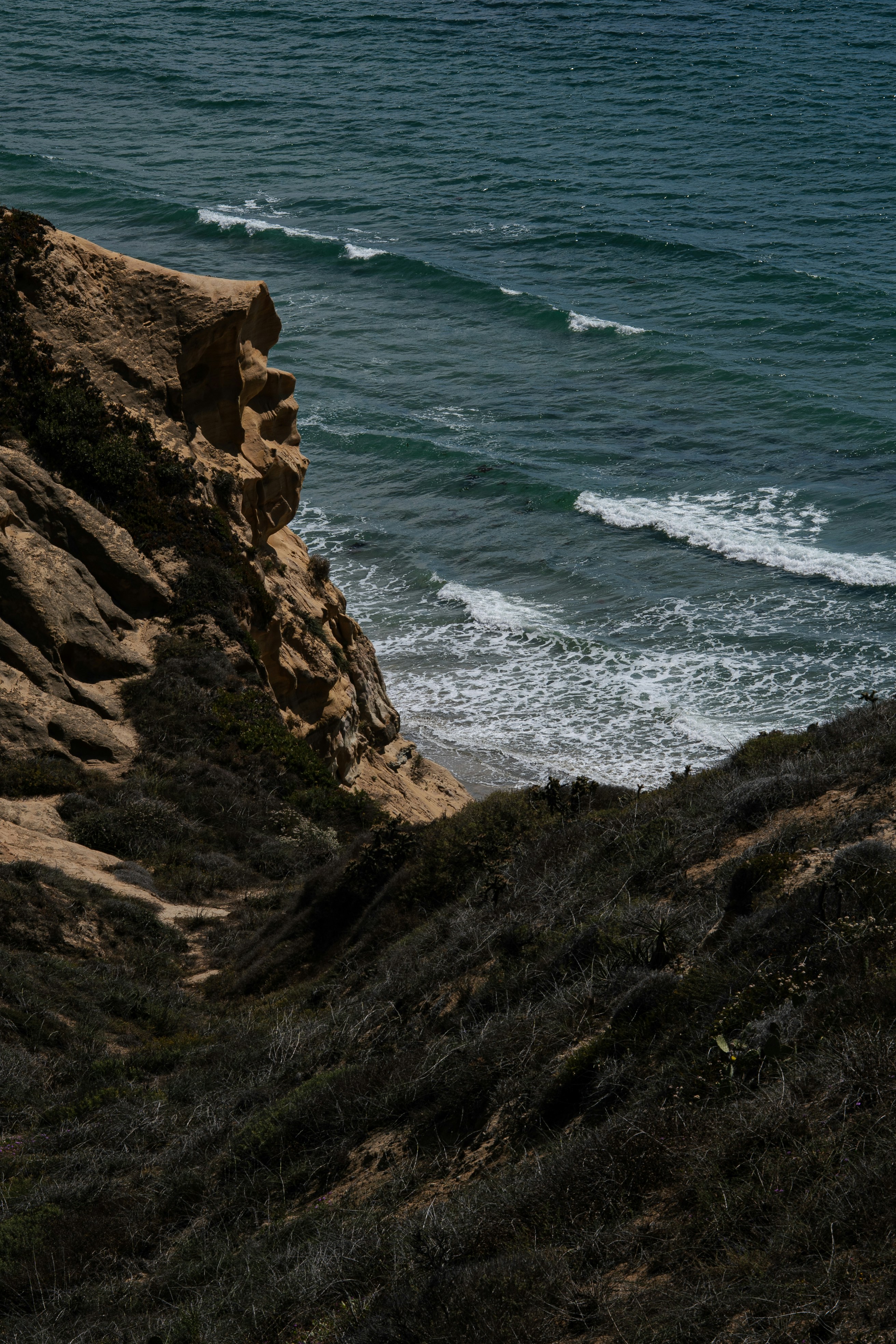 Acantilado rocoso con vistas al océano y olas rompiendo