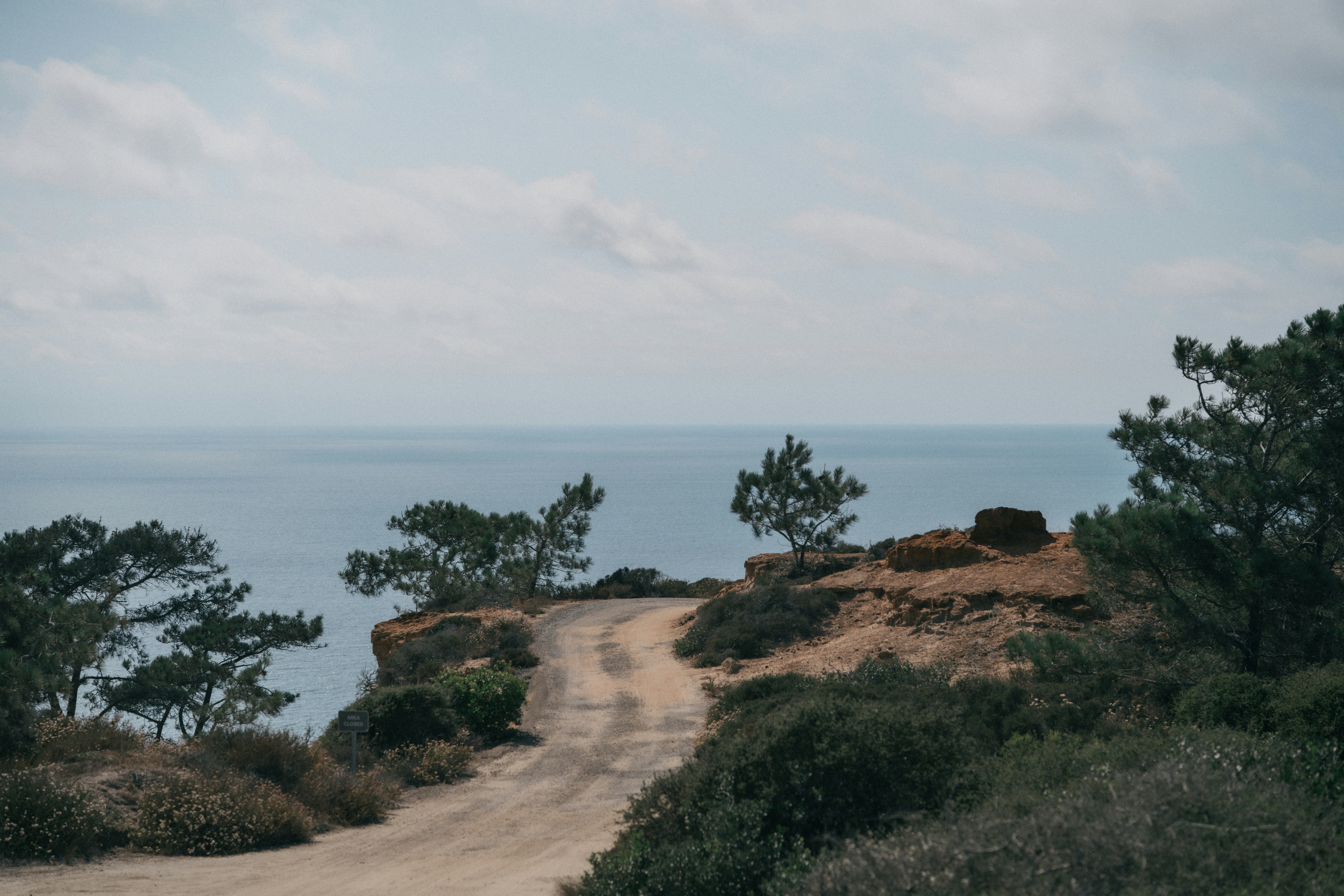 Camino de tierra que lleva al borde del acantilado del océano.