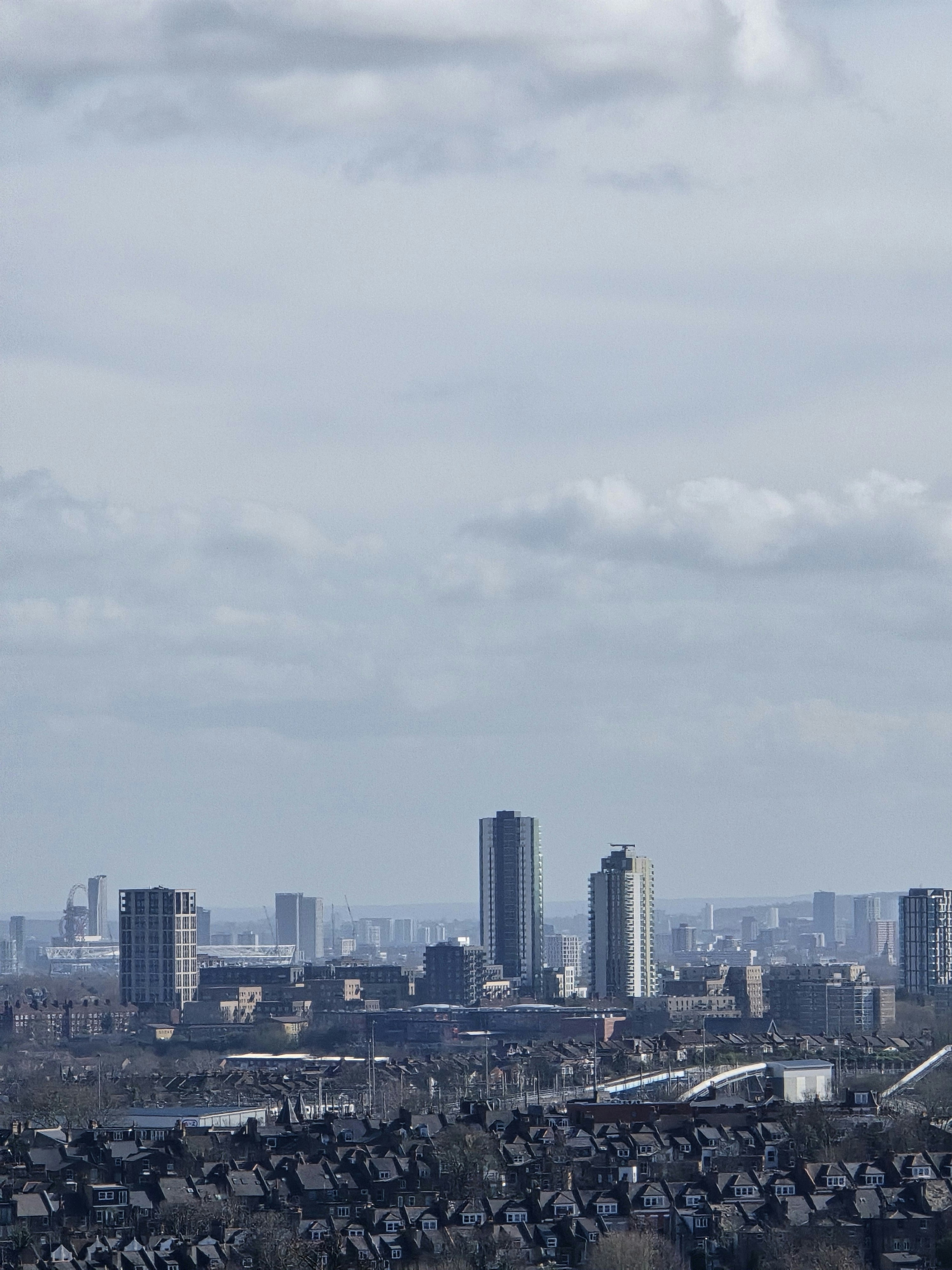 Ferne Stadtsilhouette mit hohen Gebäuden unter bewölktem Himmel