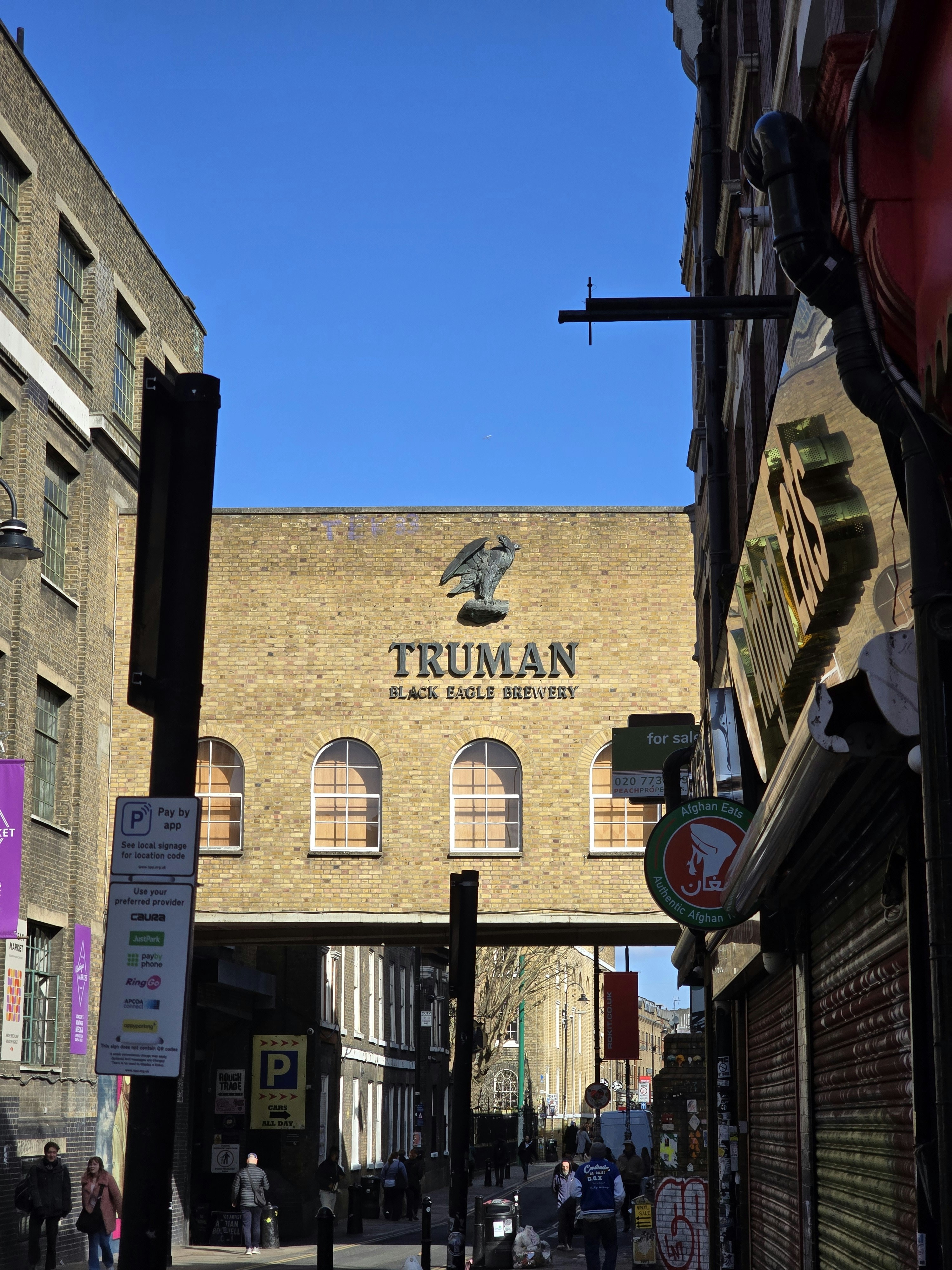 Backsteingebäude mit Truman Black Eagle-Schild unter blauem Himmel.
