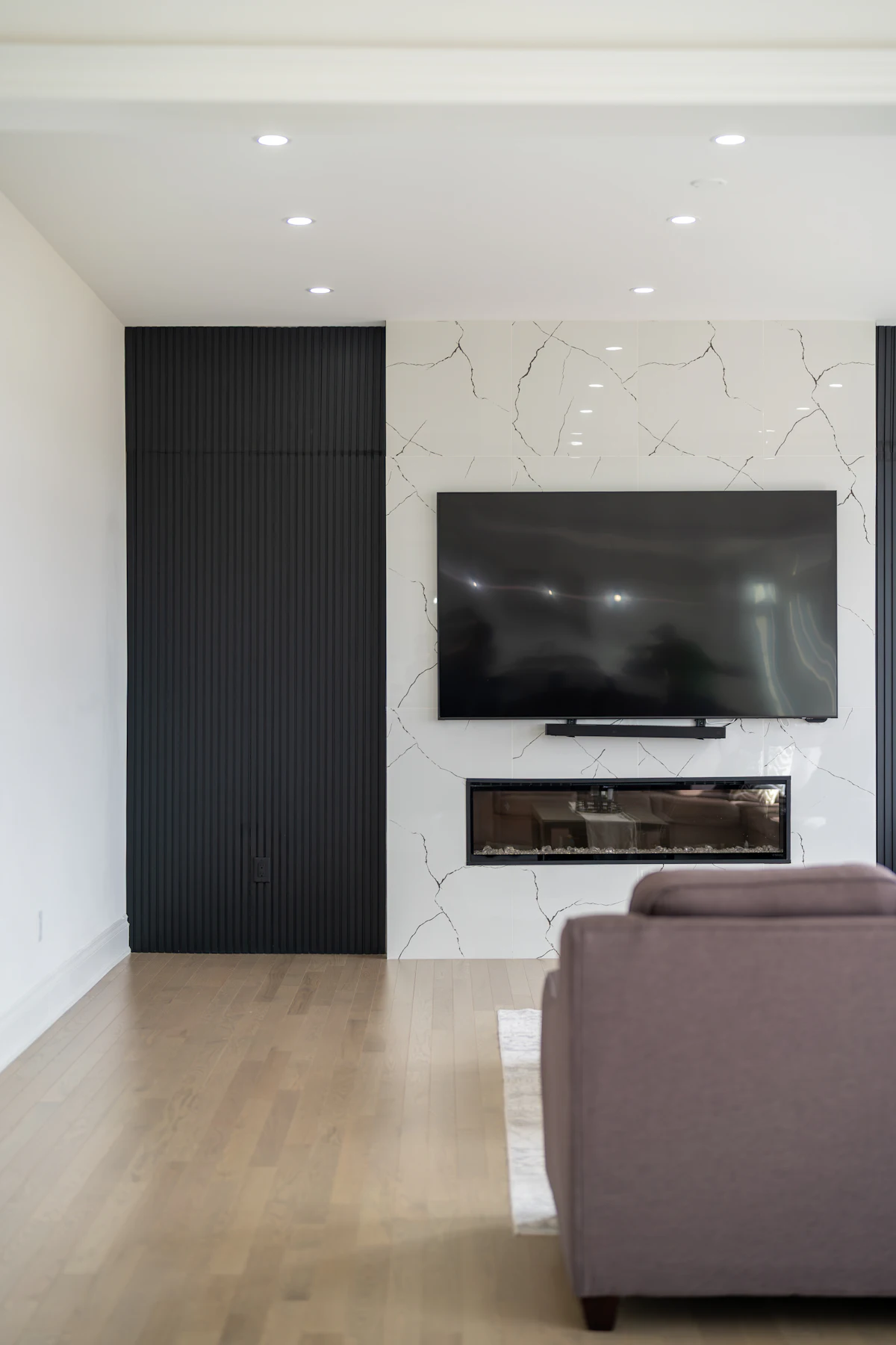 Slim television sitting flush against a dark panelled wall