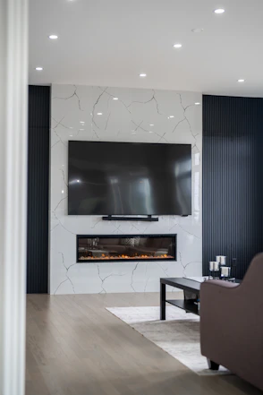 Modern living room with fireplace and large television.