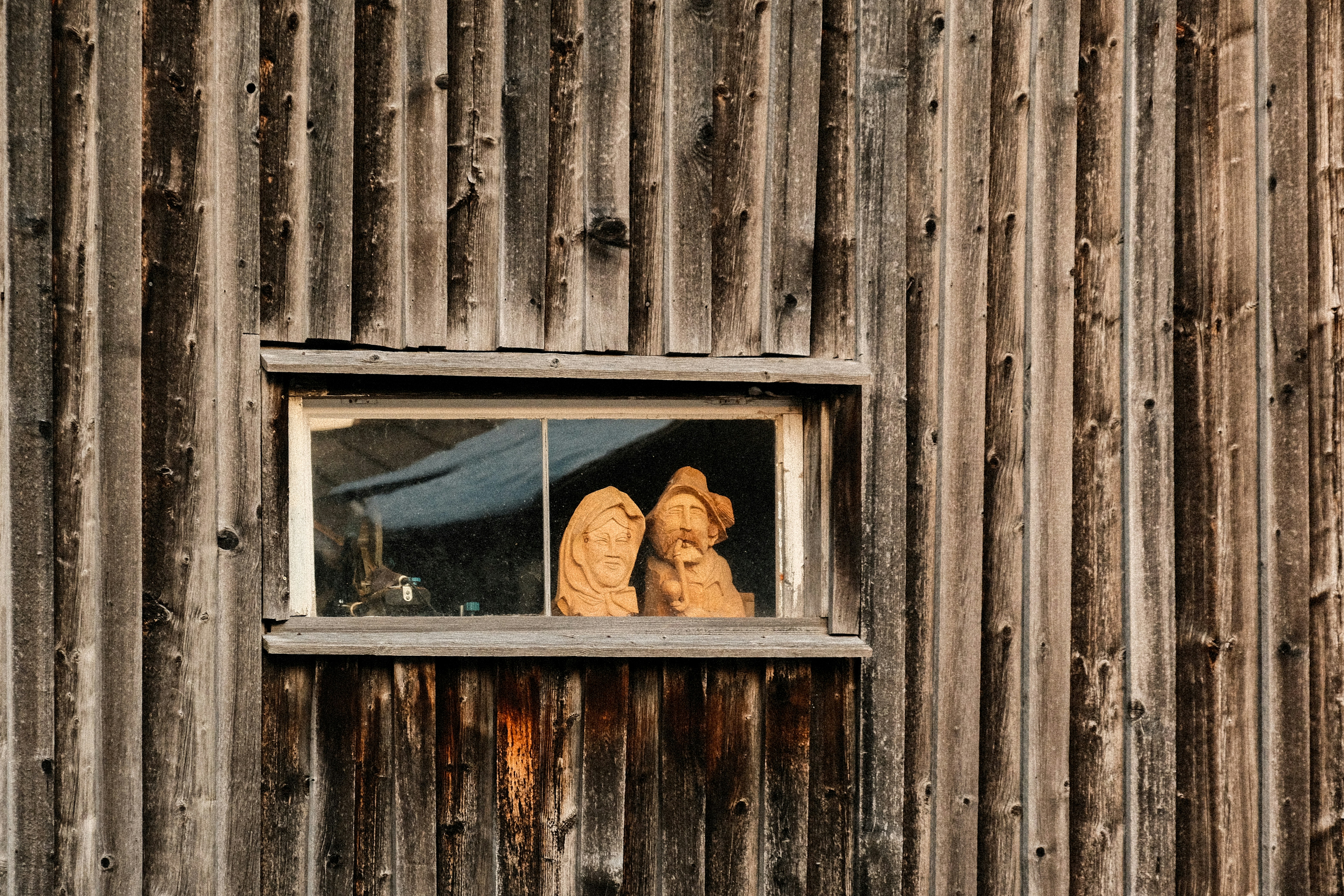 Zwei Teddybären sitzen in einem rustikalen Fenster.