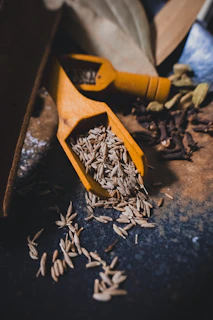 Wooden scoops filled with cumin seeds and spices
