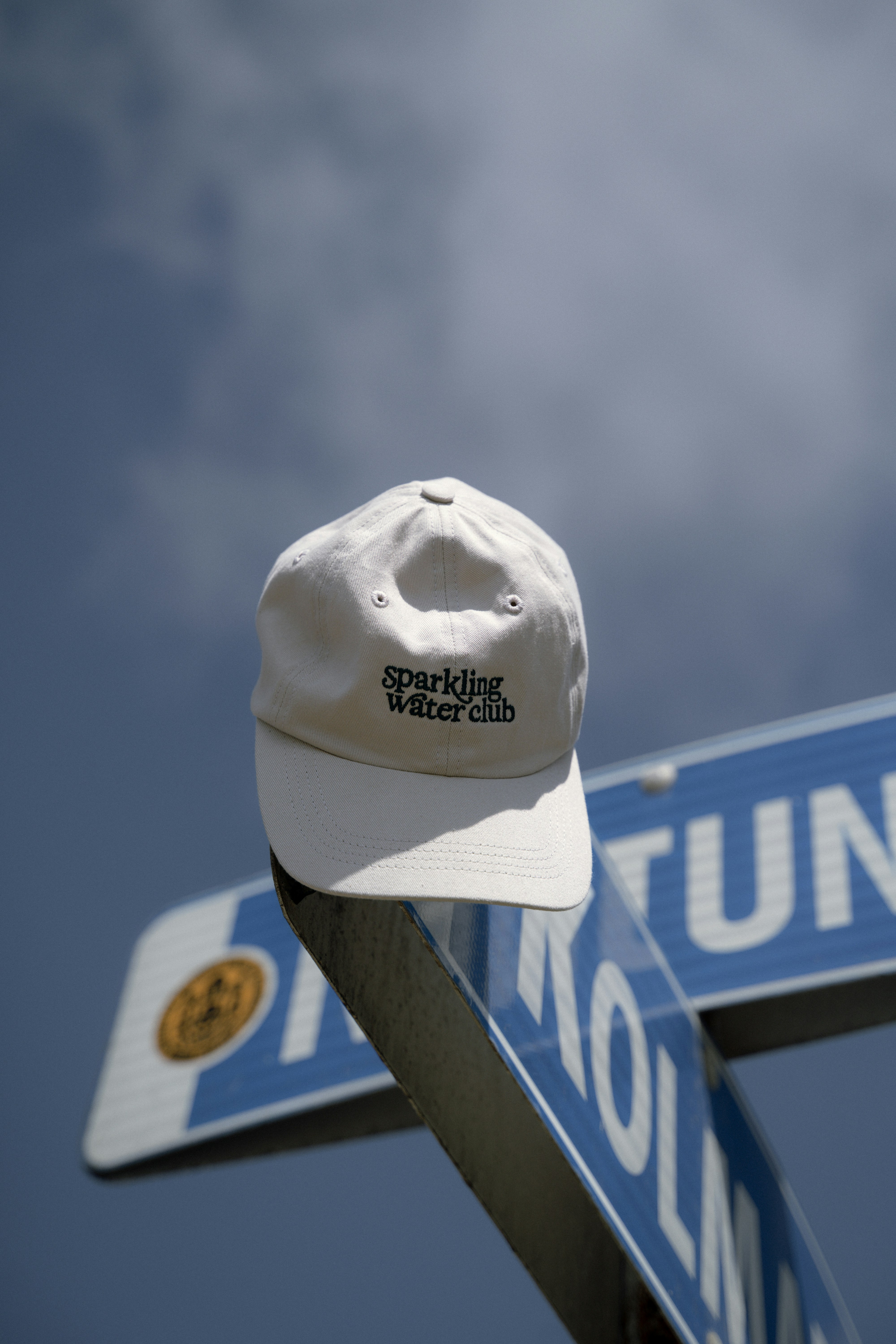 La gorra blanca de béisbol descansa sobre un cartel de la calle.