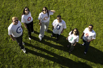 Six people in matching t-shirts on grass