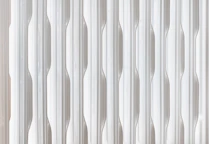 Close-up of a white radiator with vertical fins