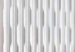 Close-up of a white radiator with vertical fins