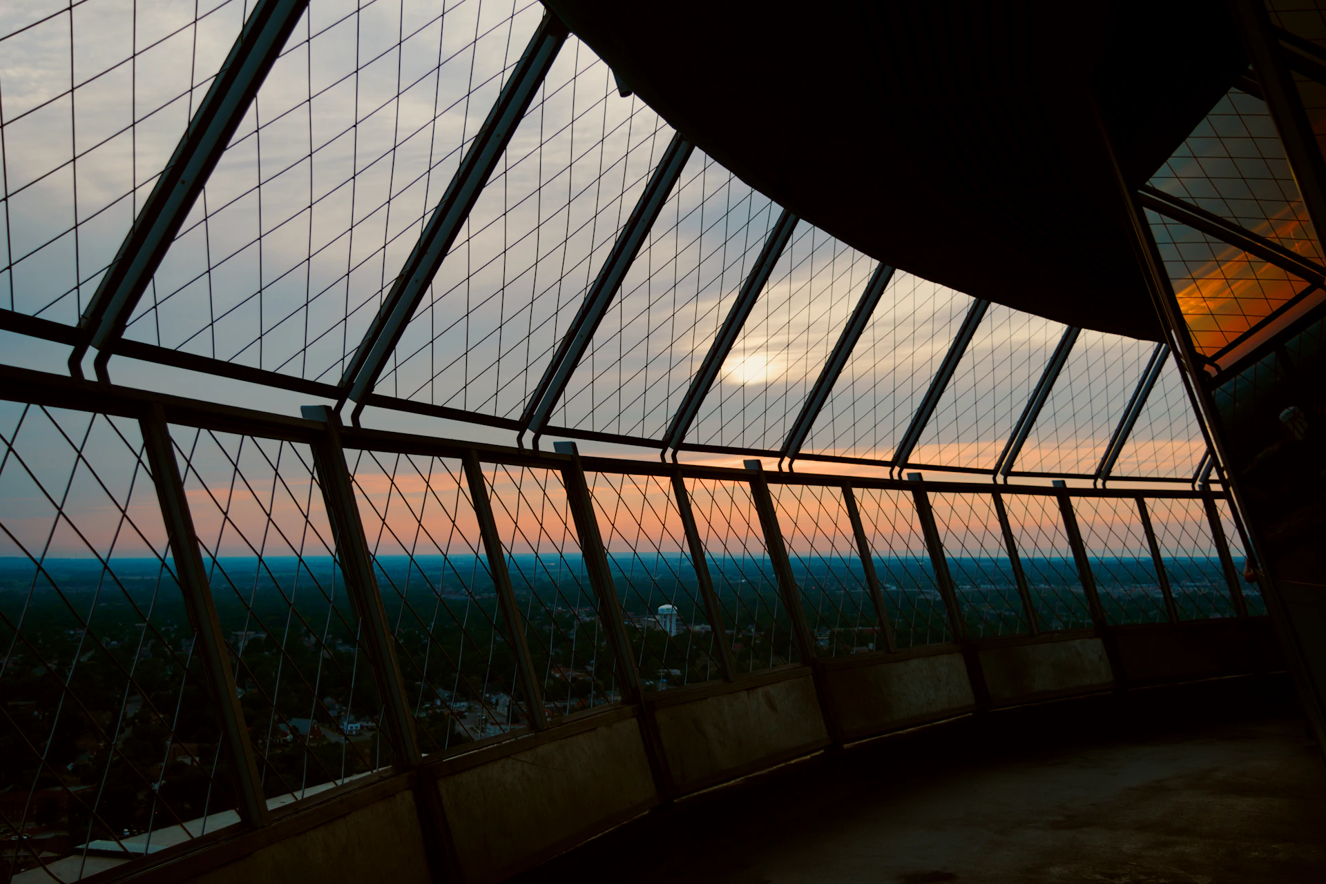 Sunset viewed through a geometric window structure.