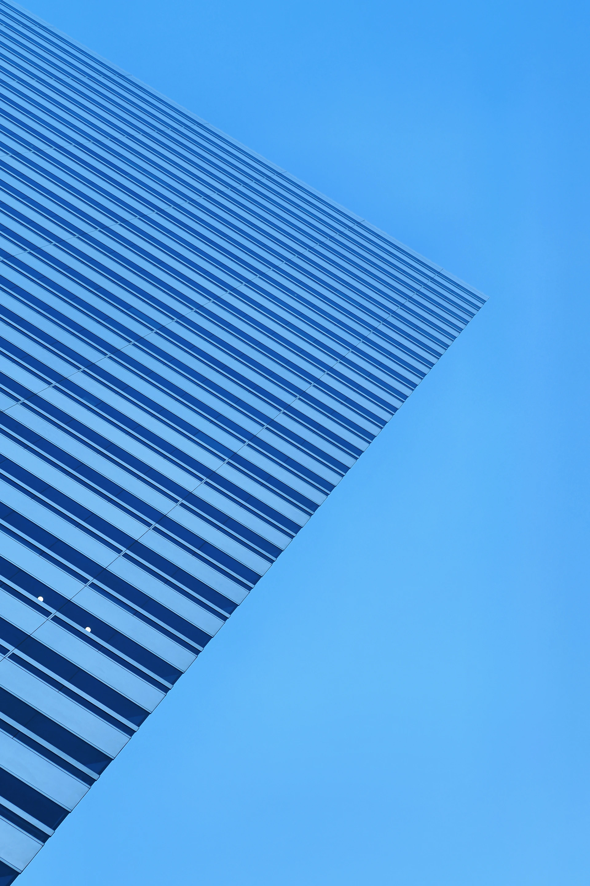 Modern skyscraper facade against a clear blue sky