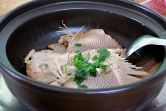Steamed fish with herbs in a clay pot