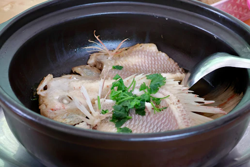 Steamed fish with herbs in a clay pot