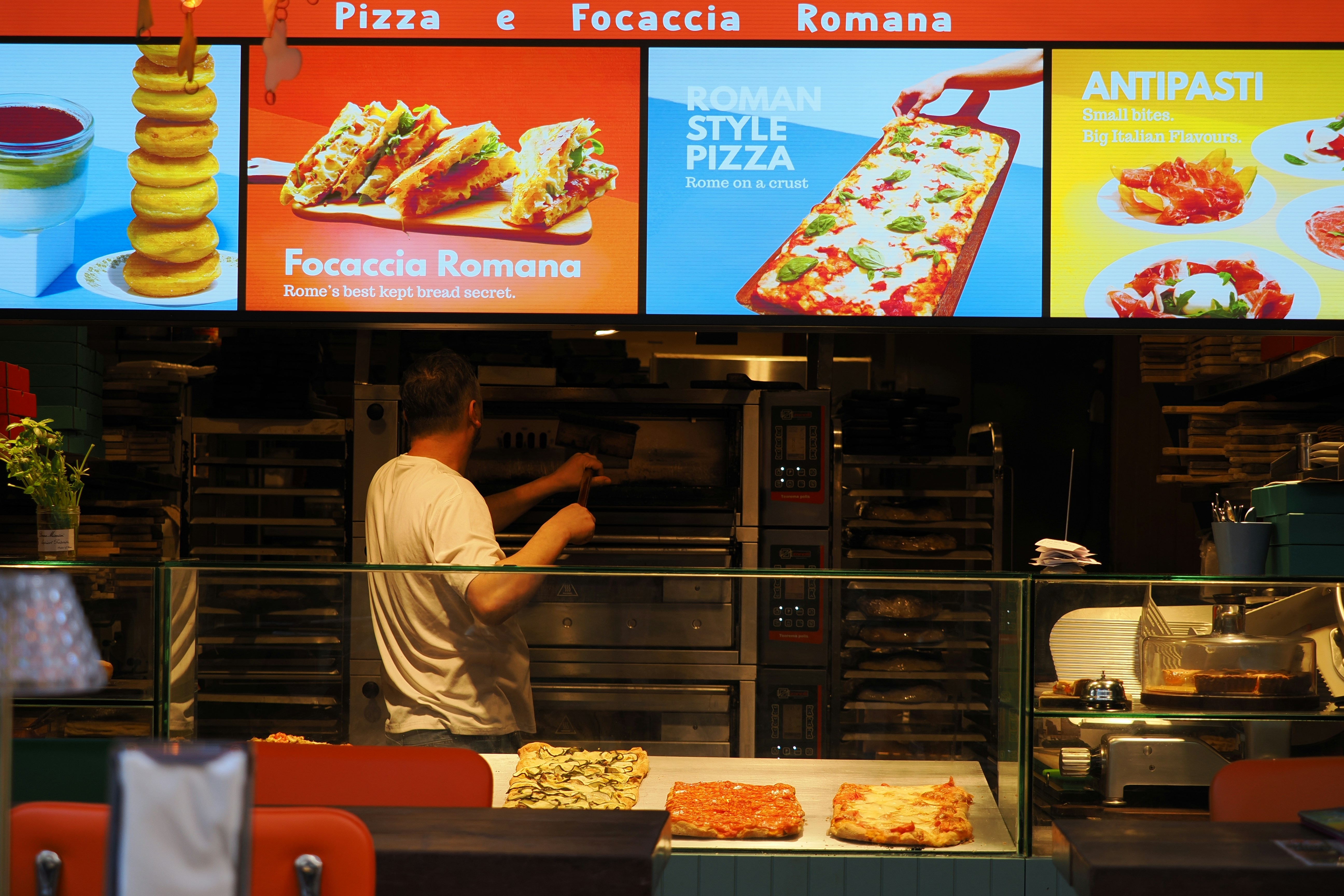 Roman style pizza and handmade pasta on a cozy Uptown restaurant table