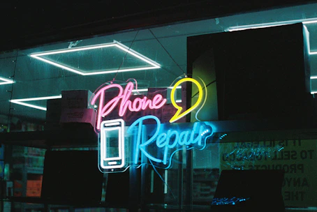 Neon "phone repair" sign with smartphone icon of a smartphone