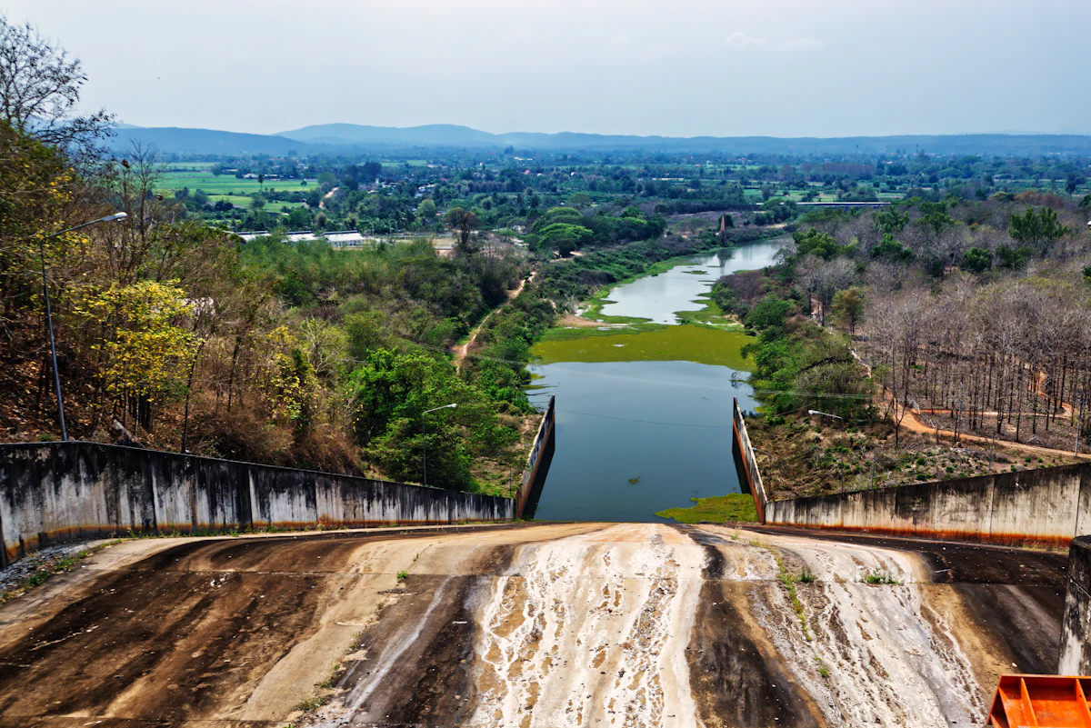 Large concrete dam spillway descending into a downstream channel — the emergency-spillway face where Texas Tuff Rock Bags hold elevation through the design storm