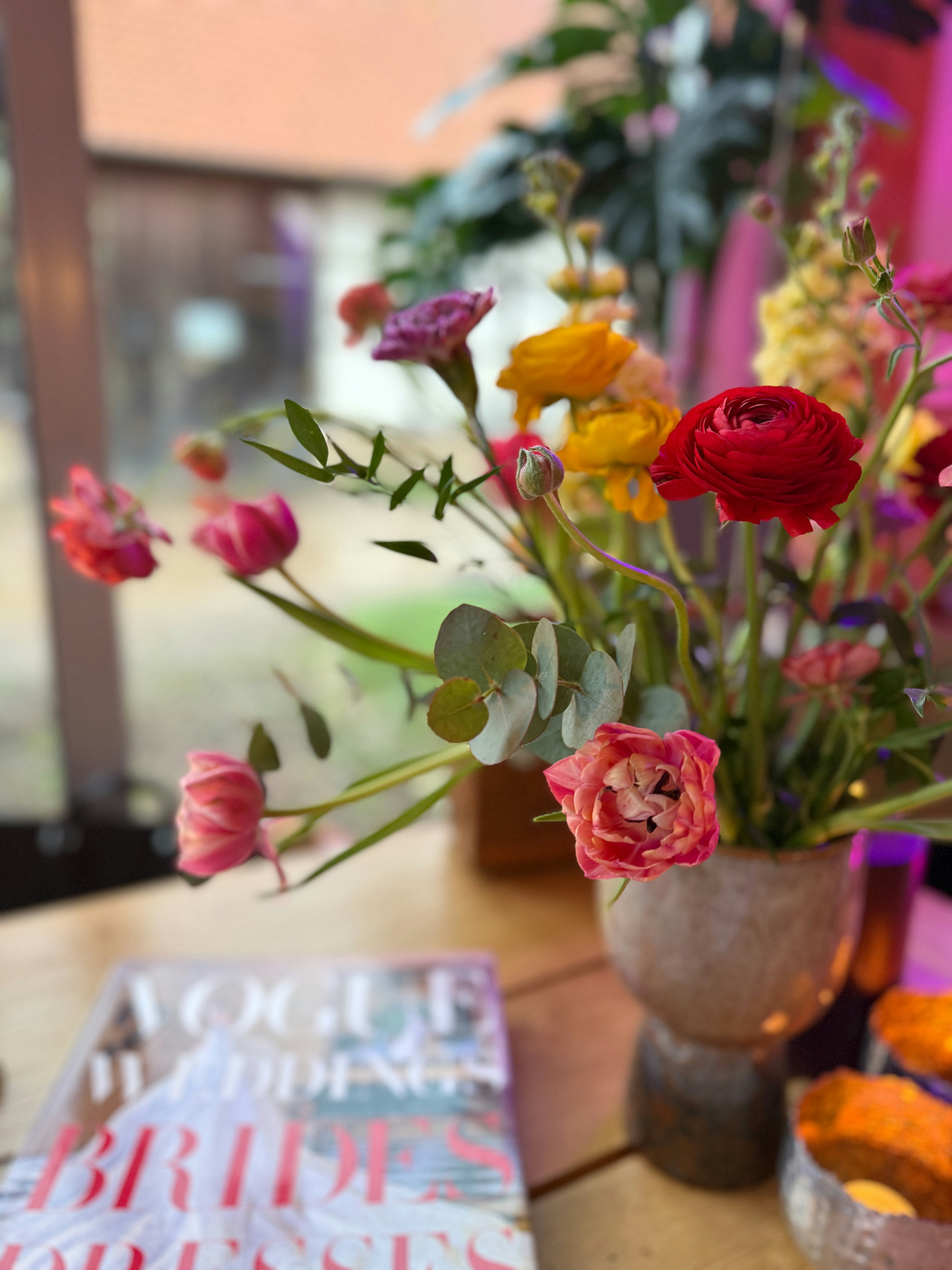 Un vaso di fiori colorati con una rivista.