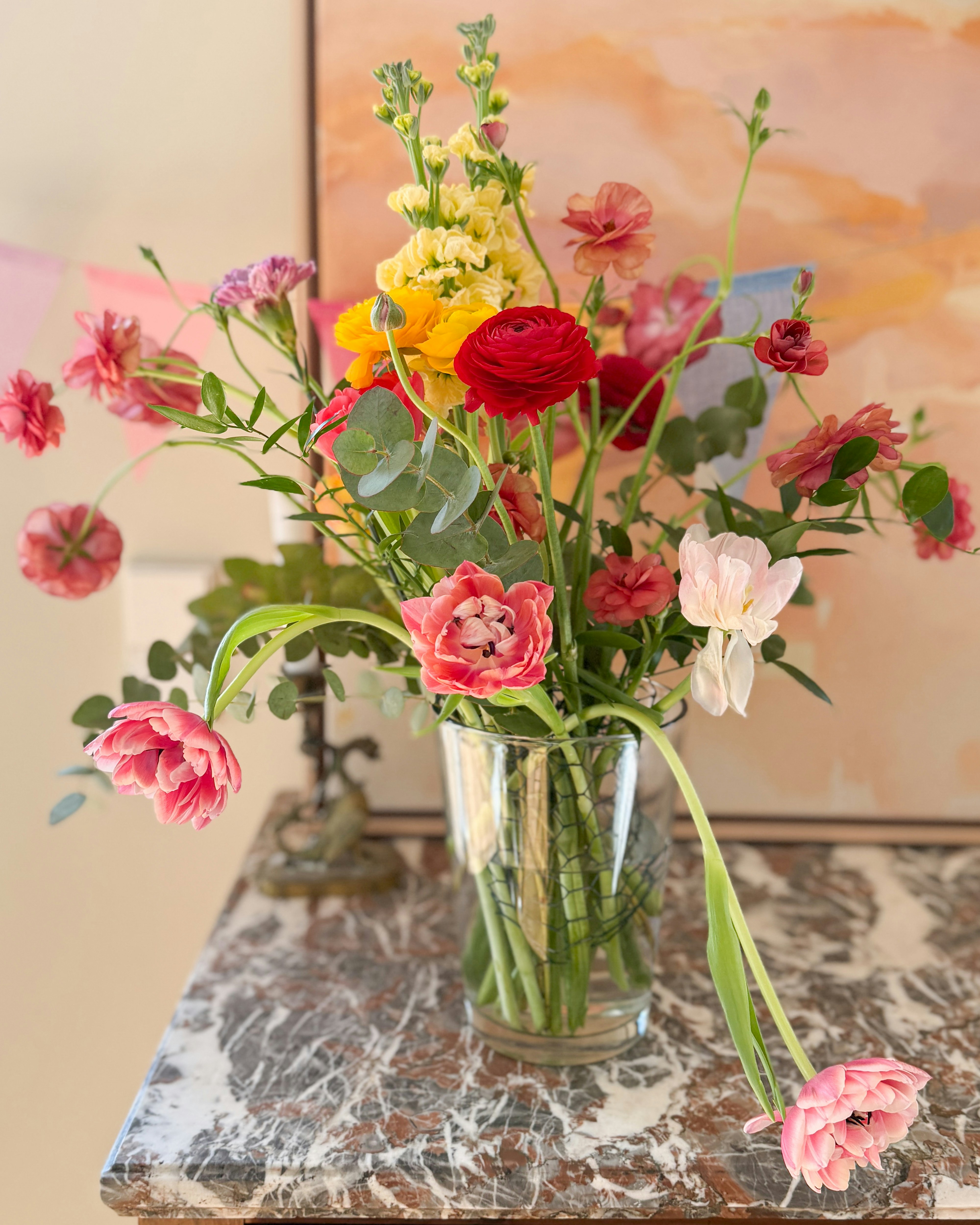 Un vivace mazzo di fiori colorati in un vaso di vetro.