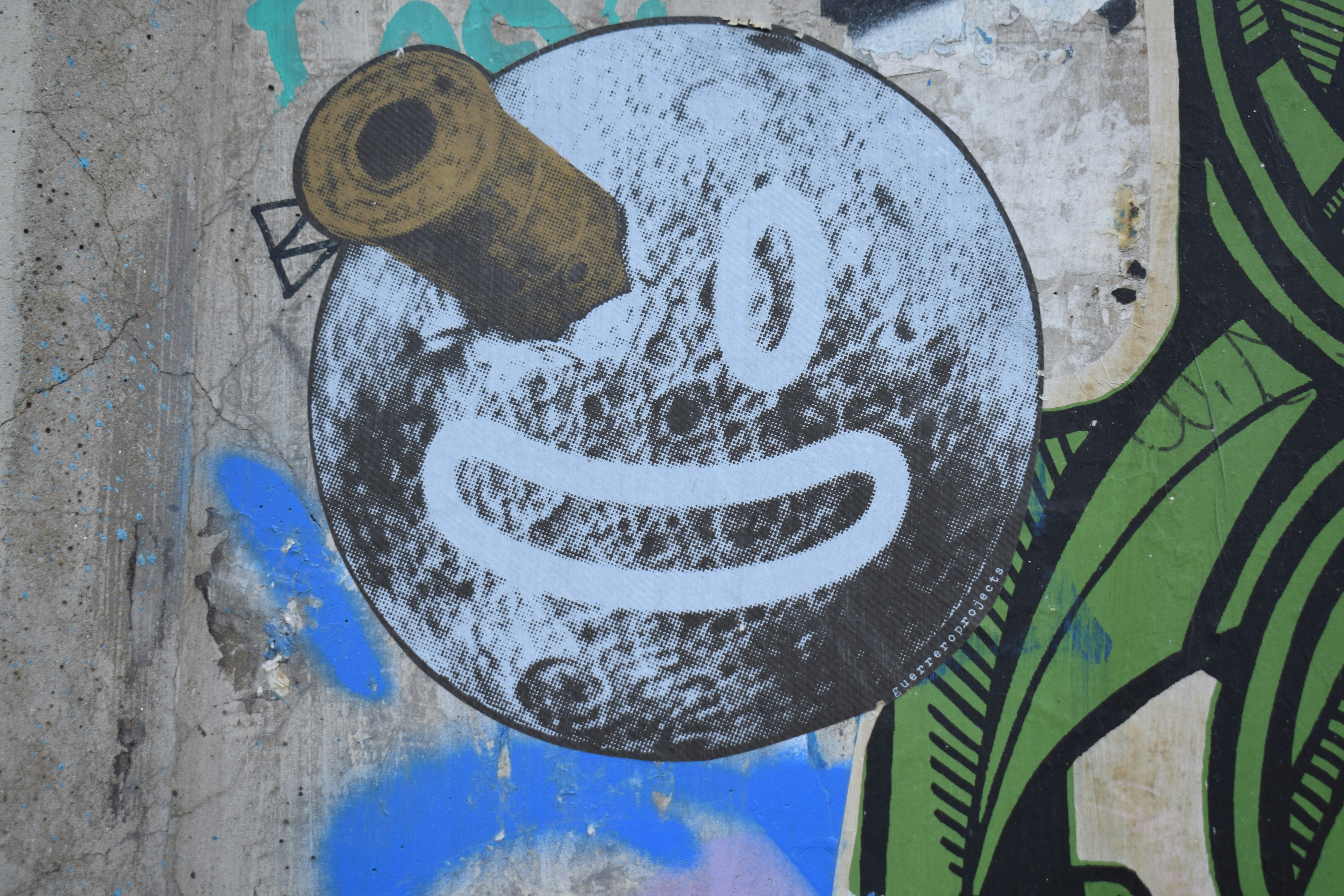 Graffiti of a smiling moon with a cannon