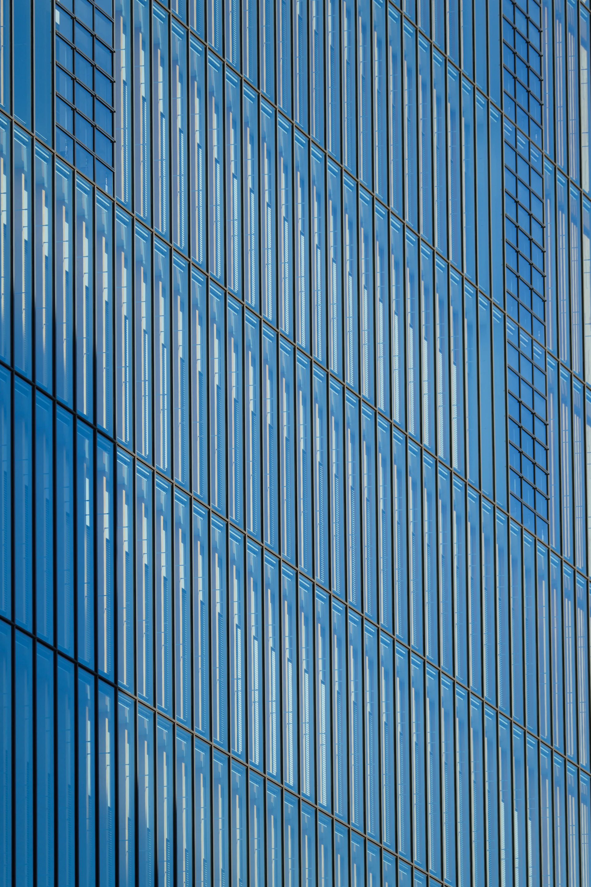 Modern glass building facade with repeating vertical lines.