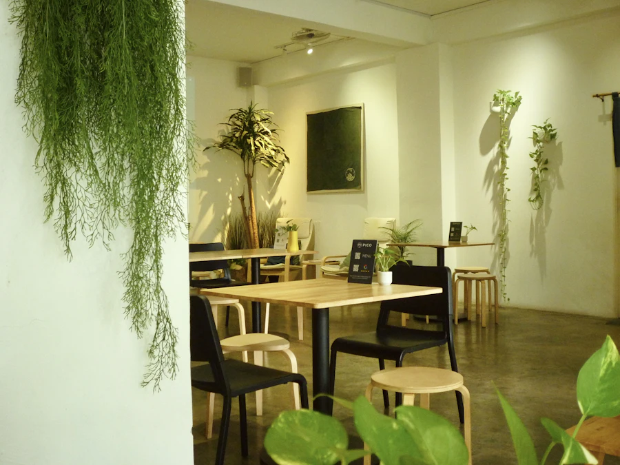 A bright café room with plants and tables
