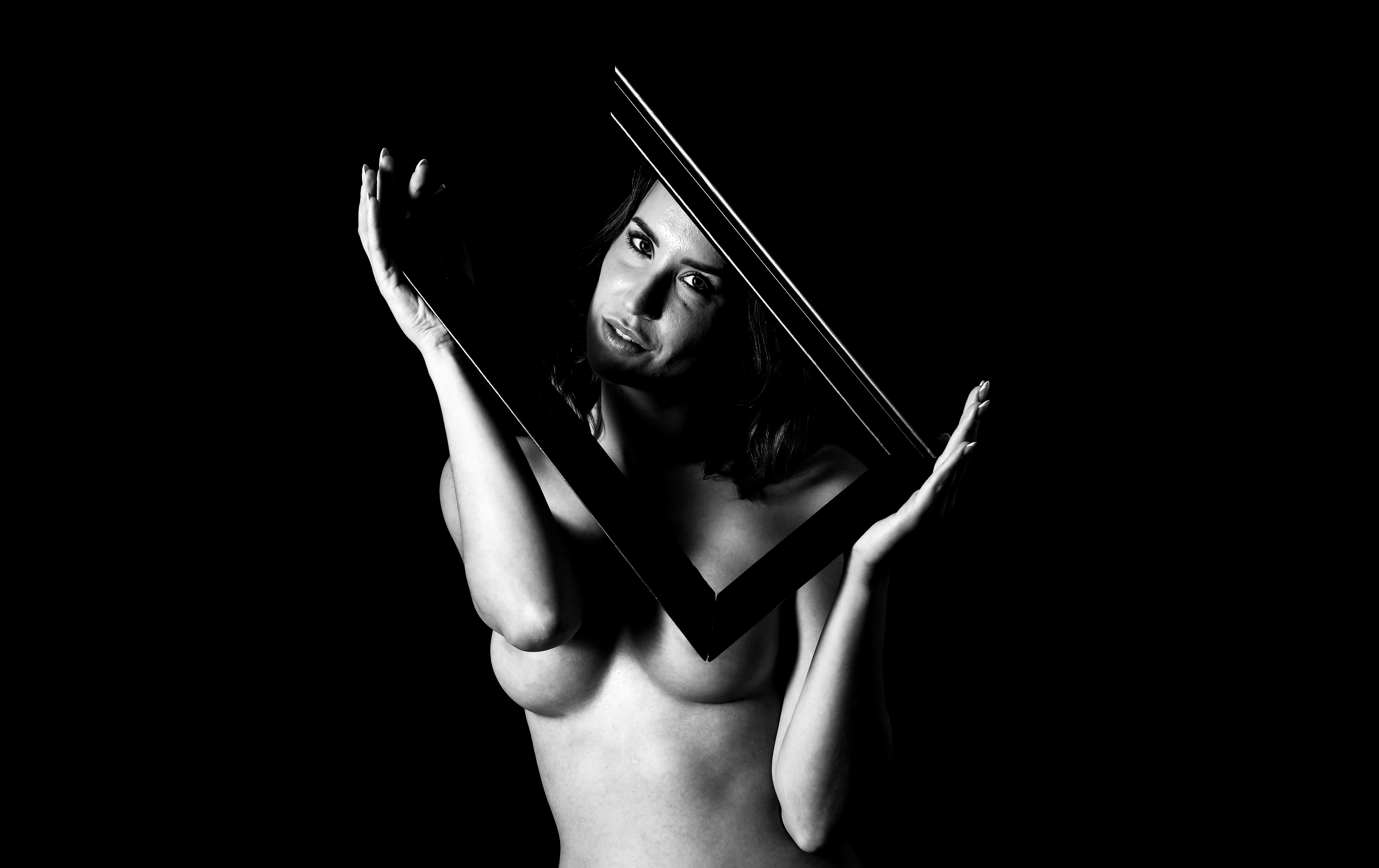 Femme tenant un cadre sur fond noir