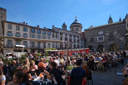 People gathered in a sunny european town square.