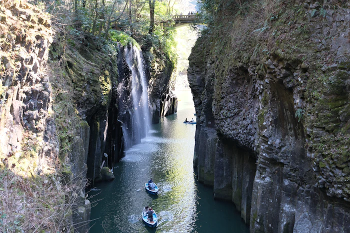 Boats in a narrow gorge with a waterfall