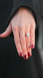 Woman's hand with a large diamond engagement ring.