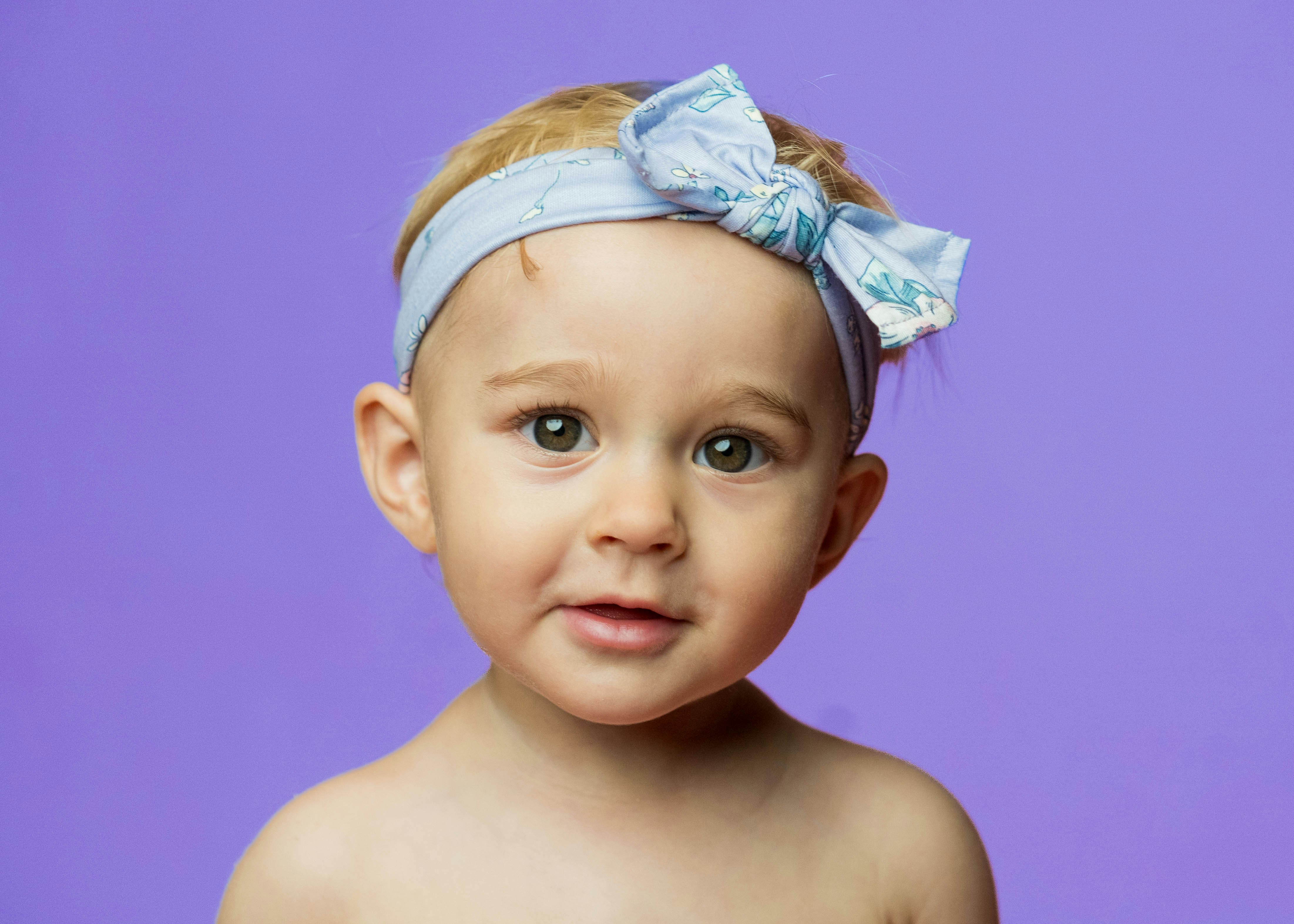 Una bambina con una fascia blu con fiocco.