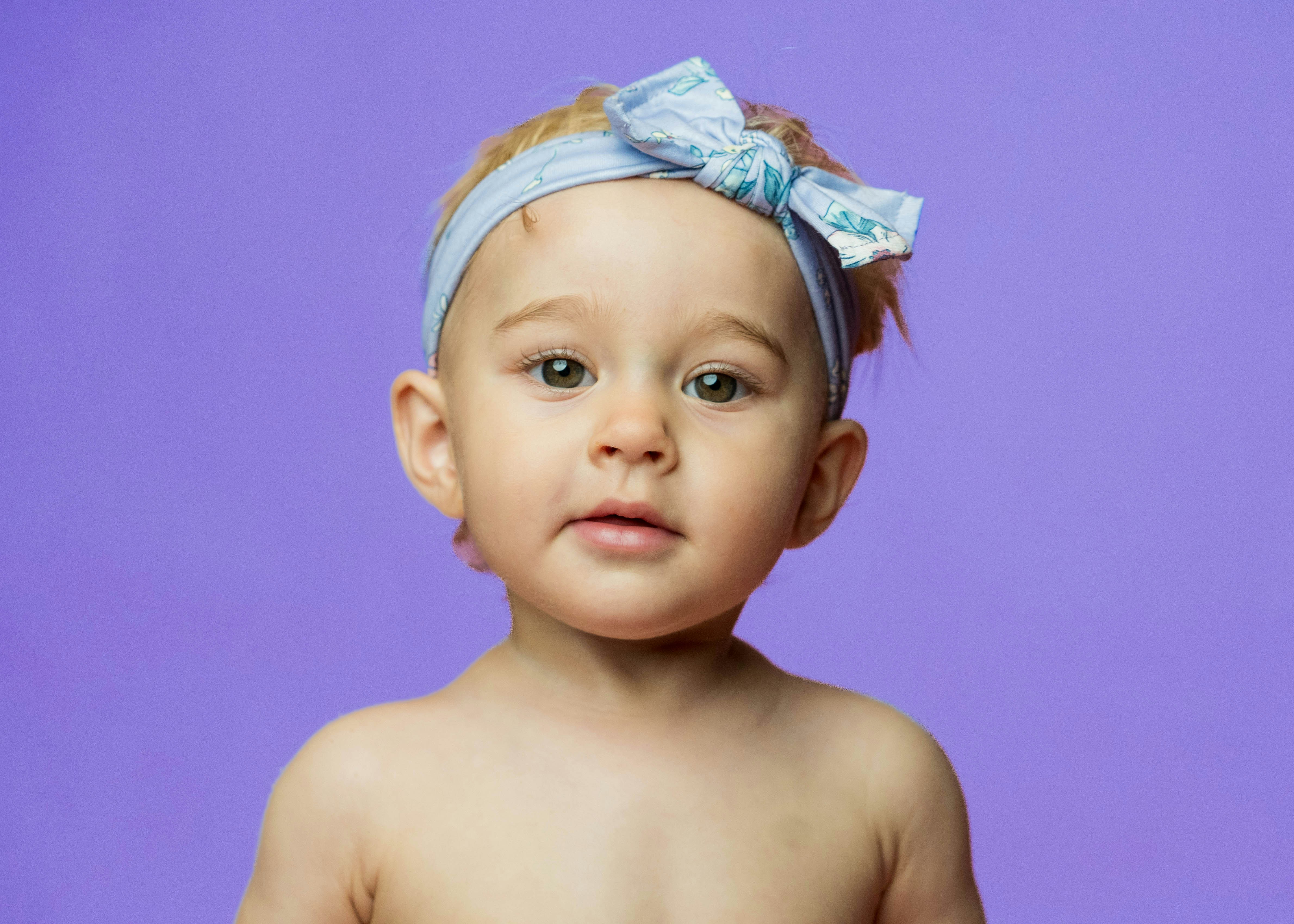 Una bambina con un fiocco blu sulla testa