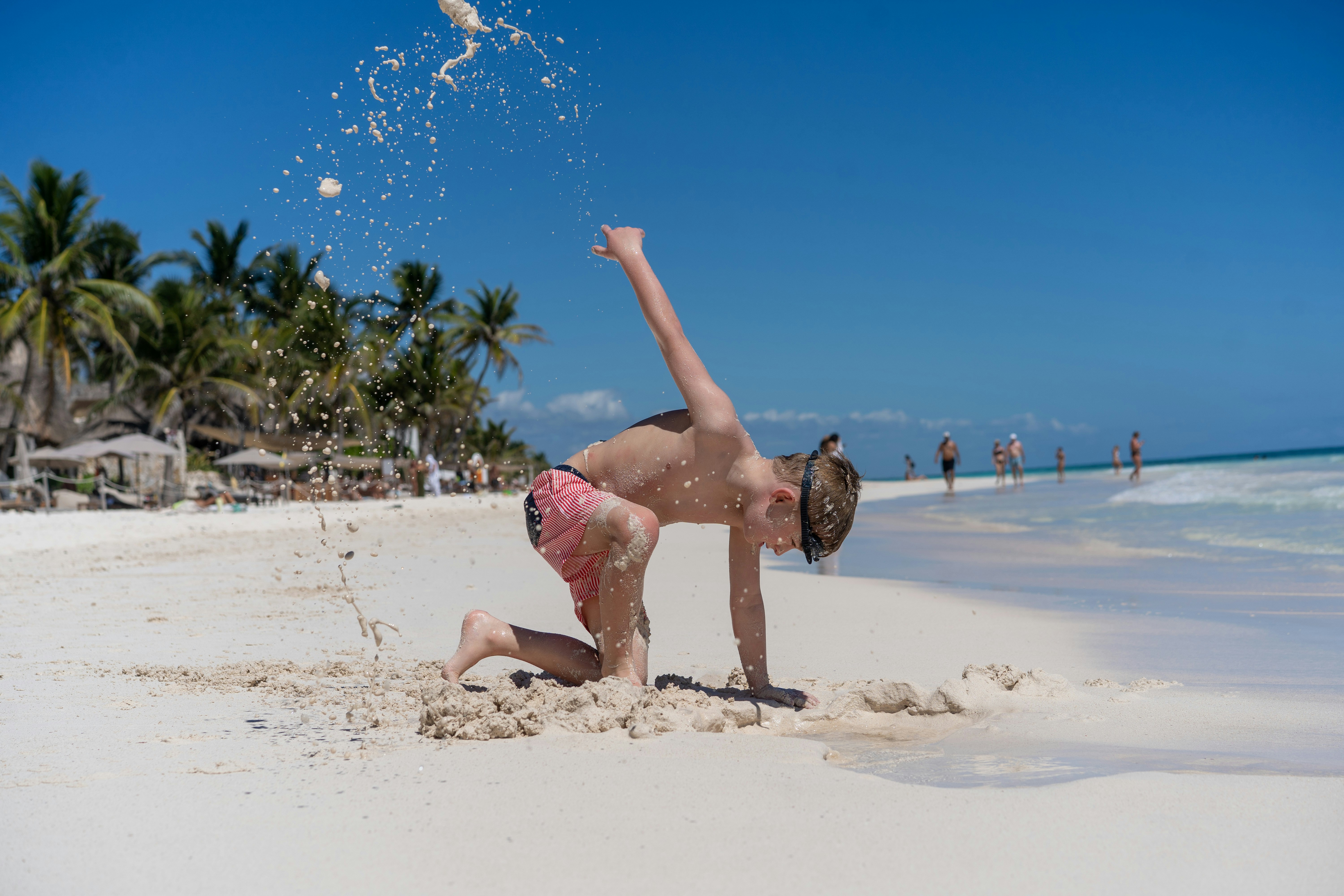 Bambino che gioca sulla sabbia su una spiaggia soleggiata