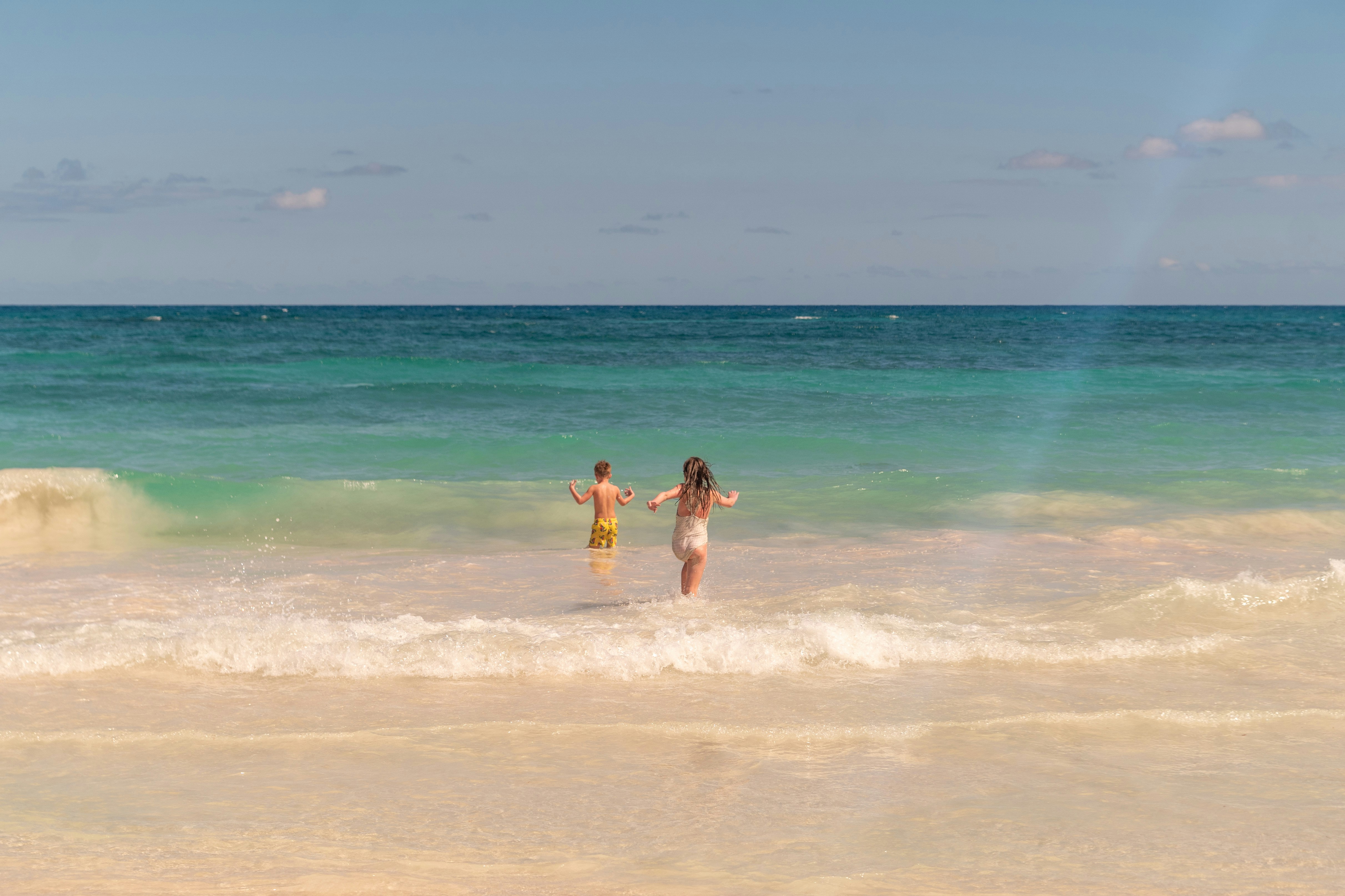 Due persone in piedi tra le onde dell'oceano