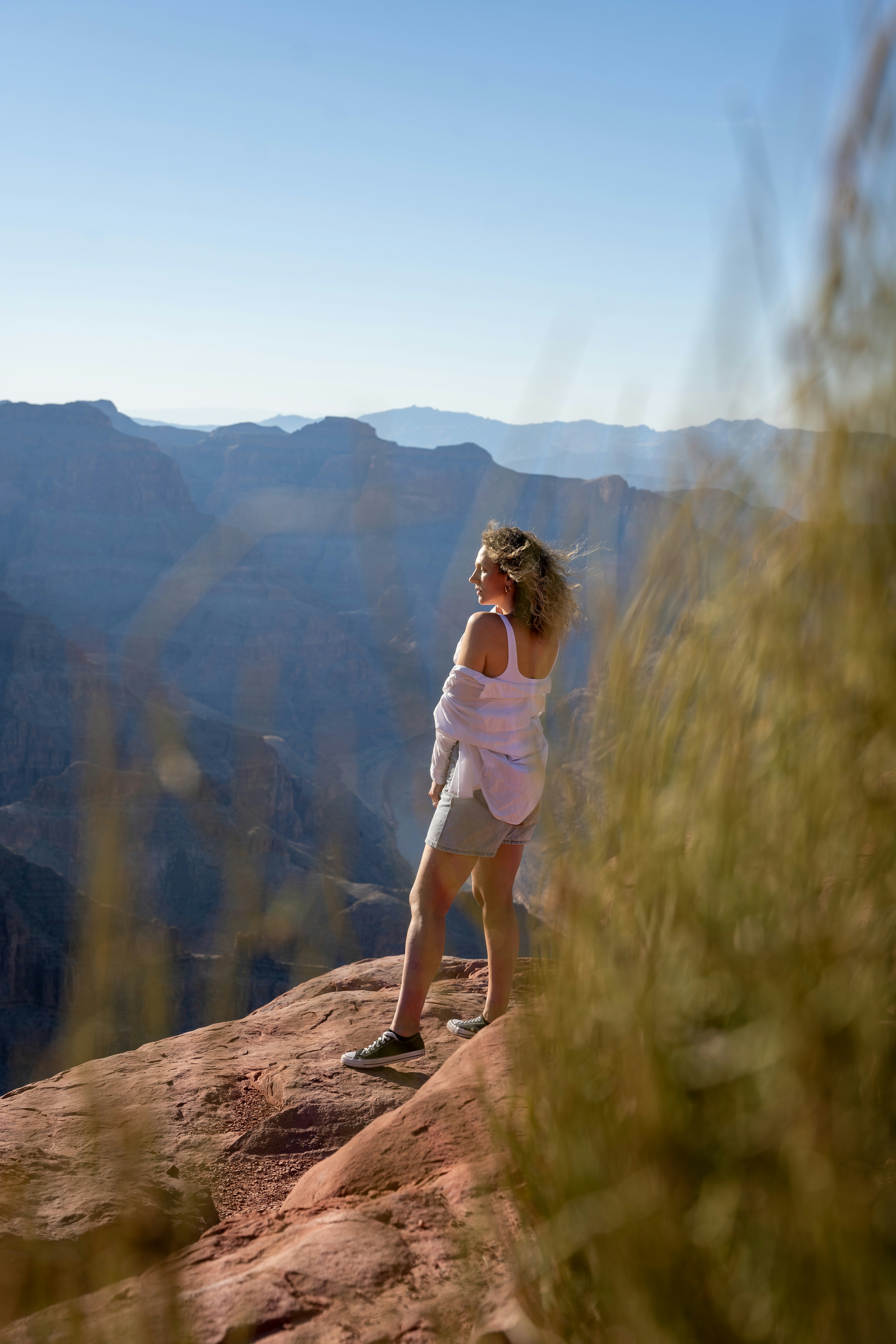 Donna in piedi su una scogliera che domina un canyon