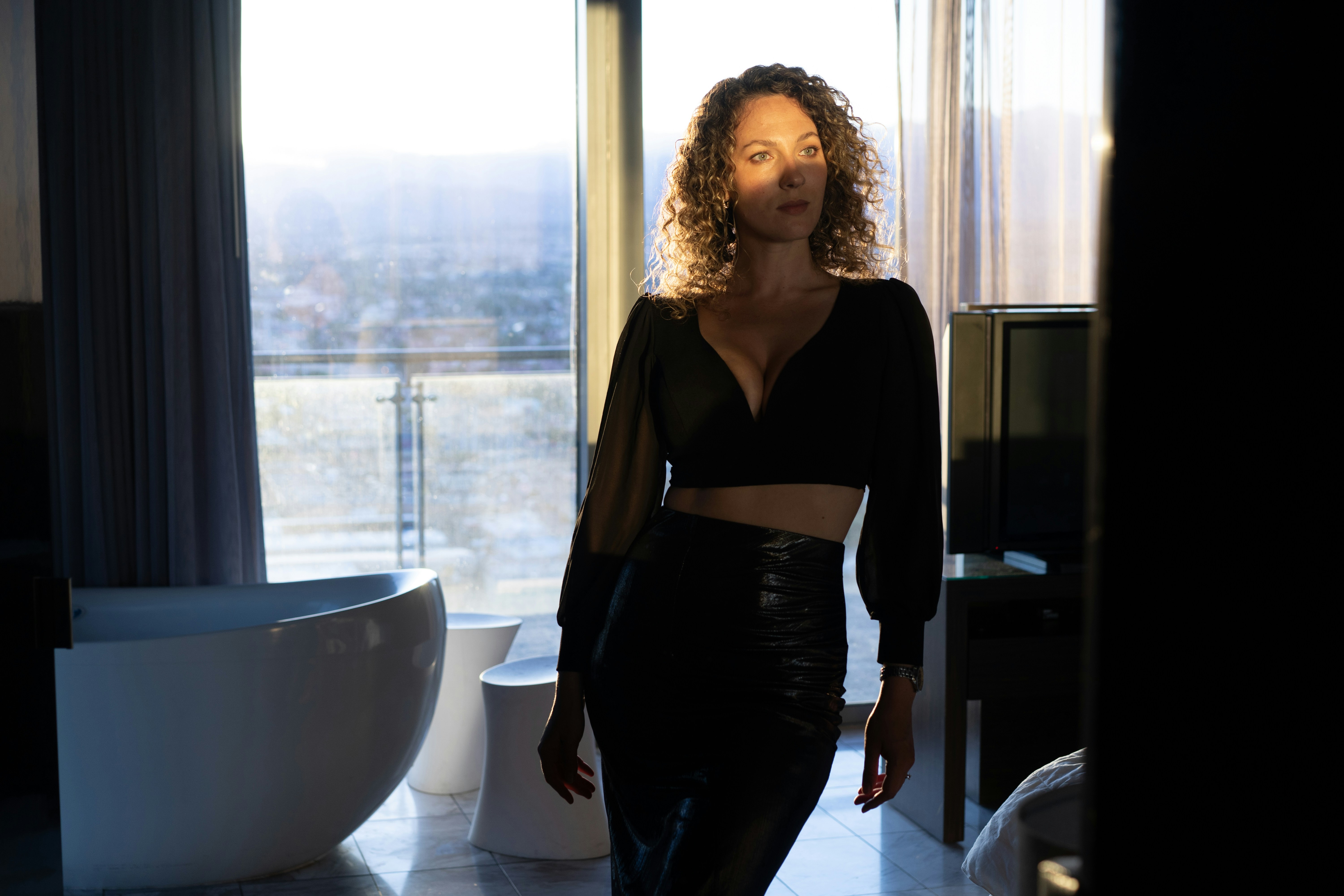 Donna in abito nero che posa vicino a una finestra