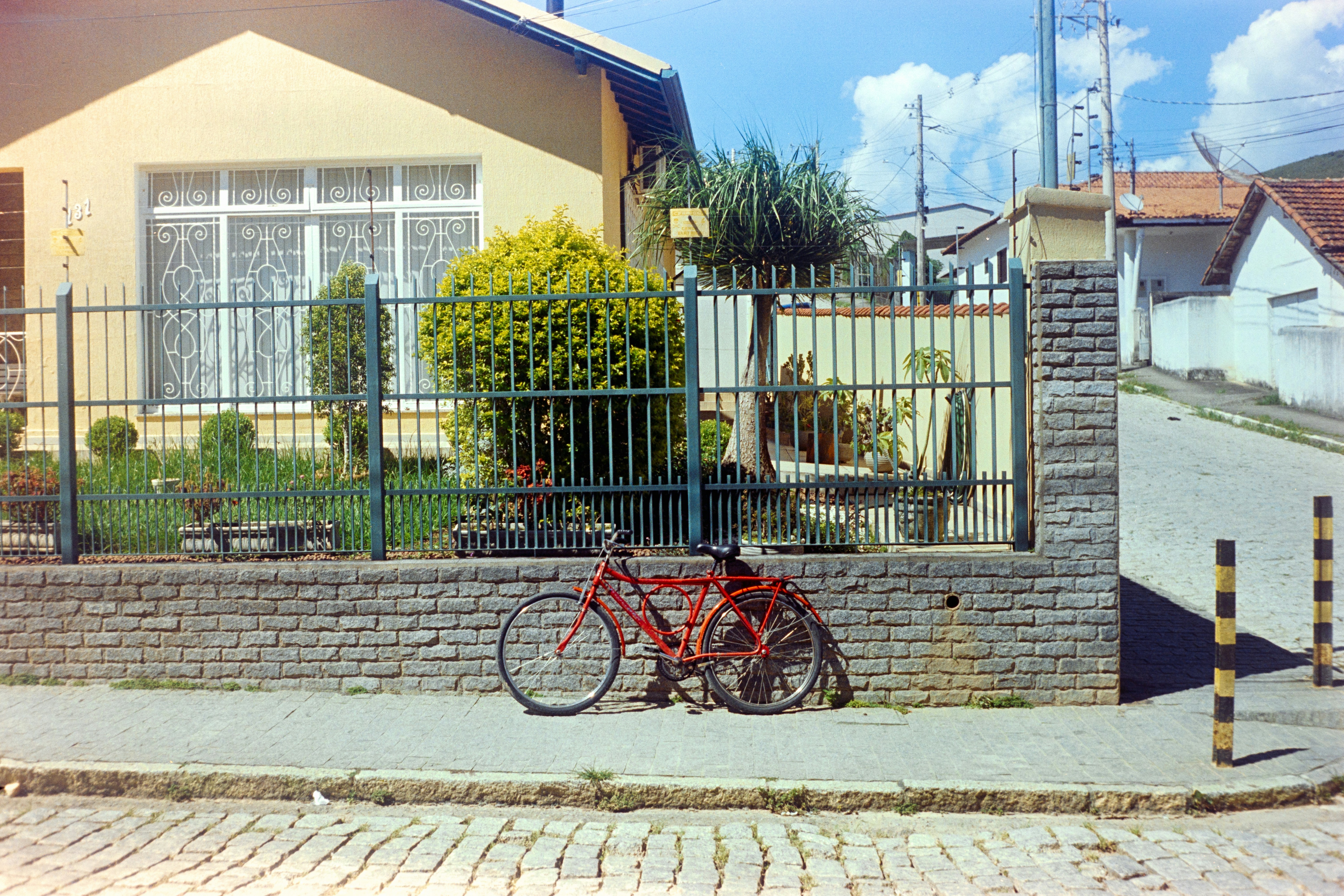 A red bicycle leans against a stone wall.