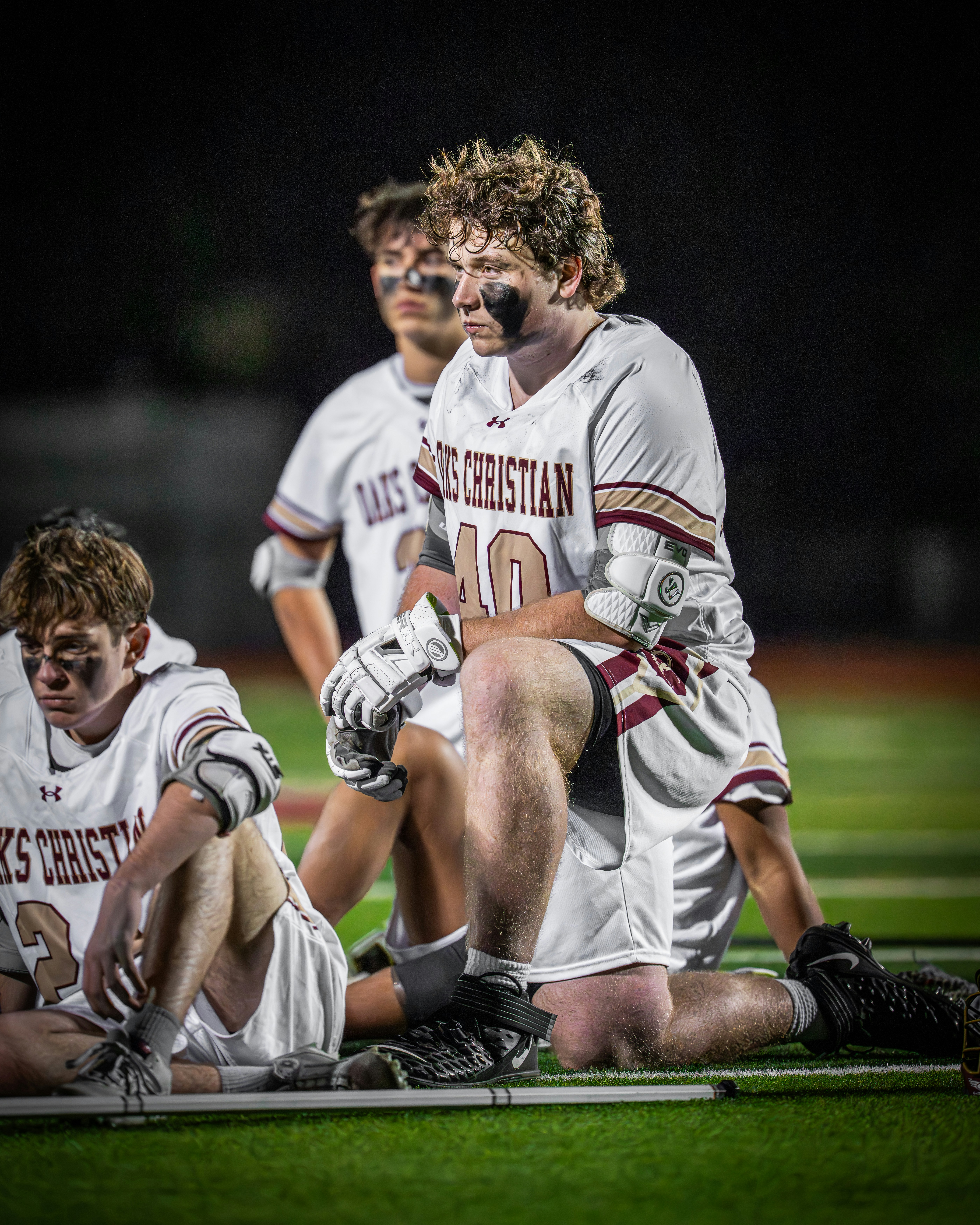 Lacrosse players in uniform on a field