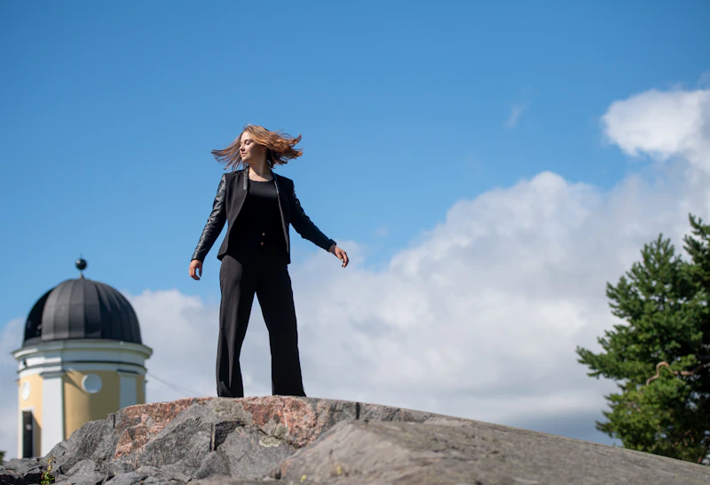 mujer ejecutiva en traje negro con vistas al mar