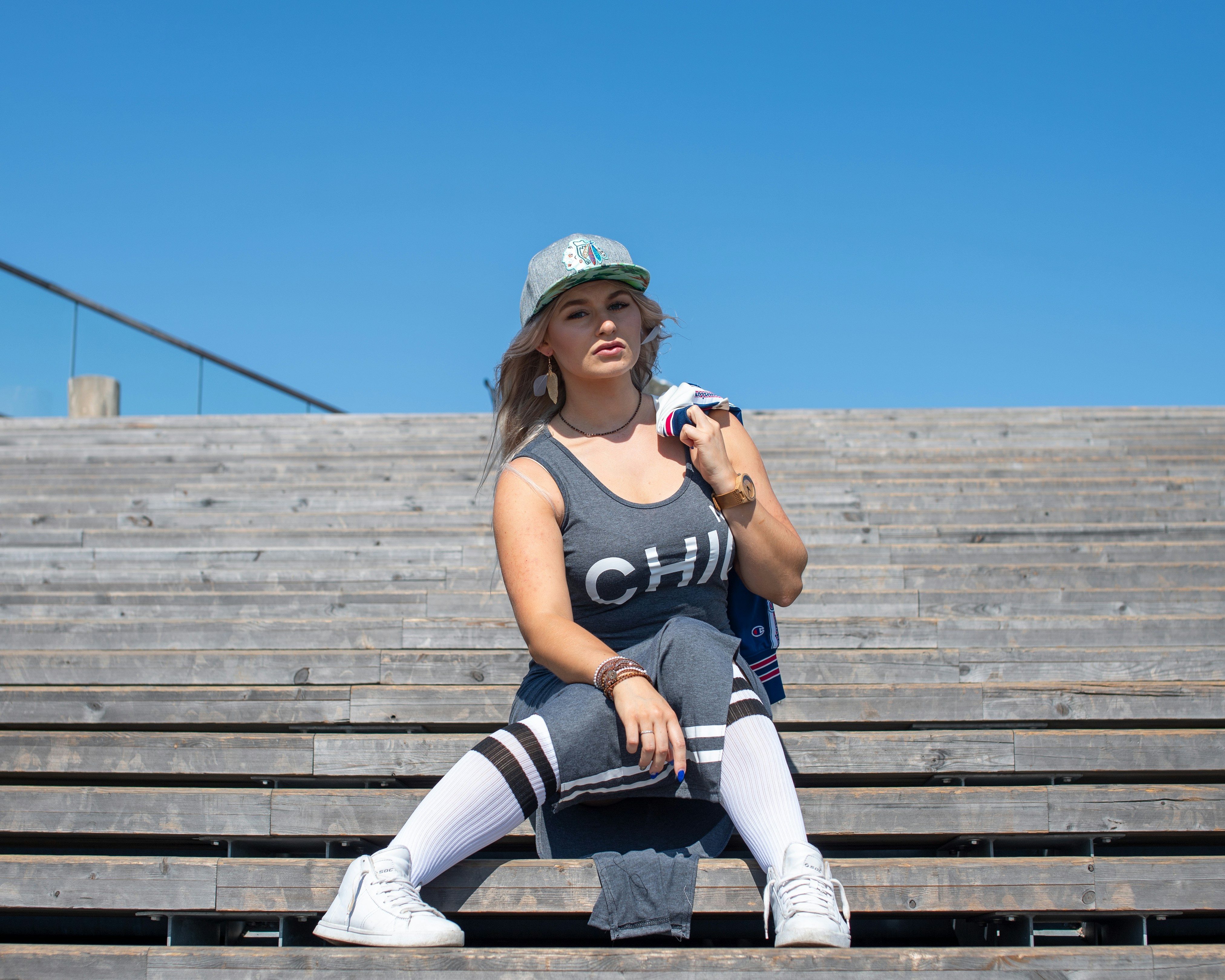 Woman in athletic wear sits on wooden bleachers