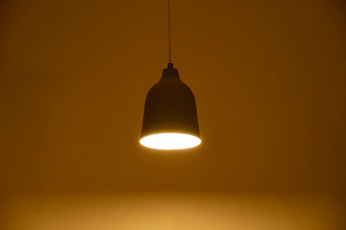 A single pendant light illuminates a dark room.