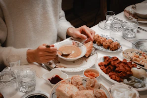 Person eating a bowl of soup with bread and bread