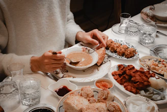 Person eating a bowl of soup with bread and bread