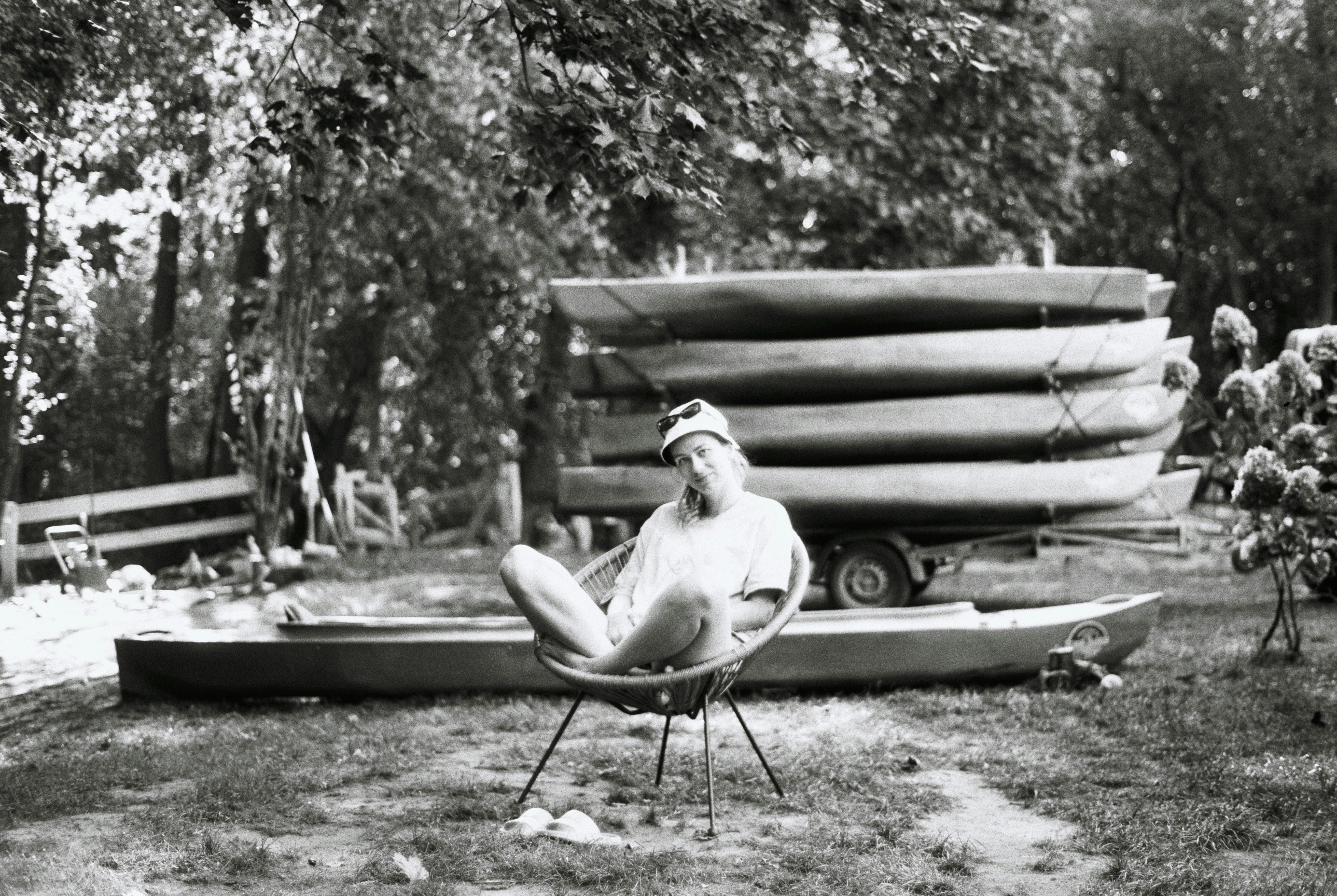 Person relaxing near stacked canoes on trailer