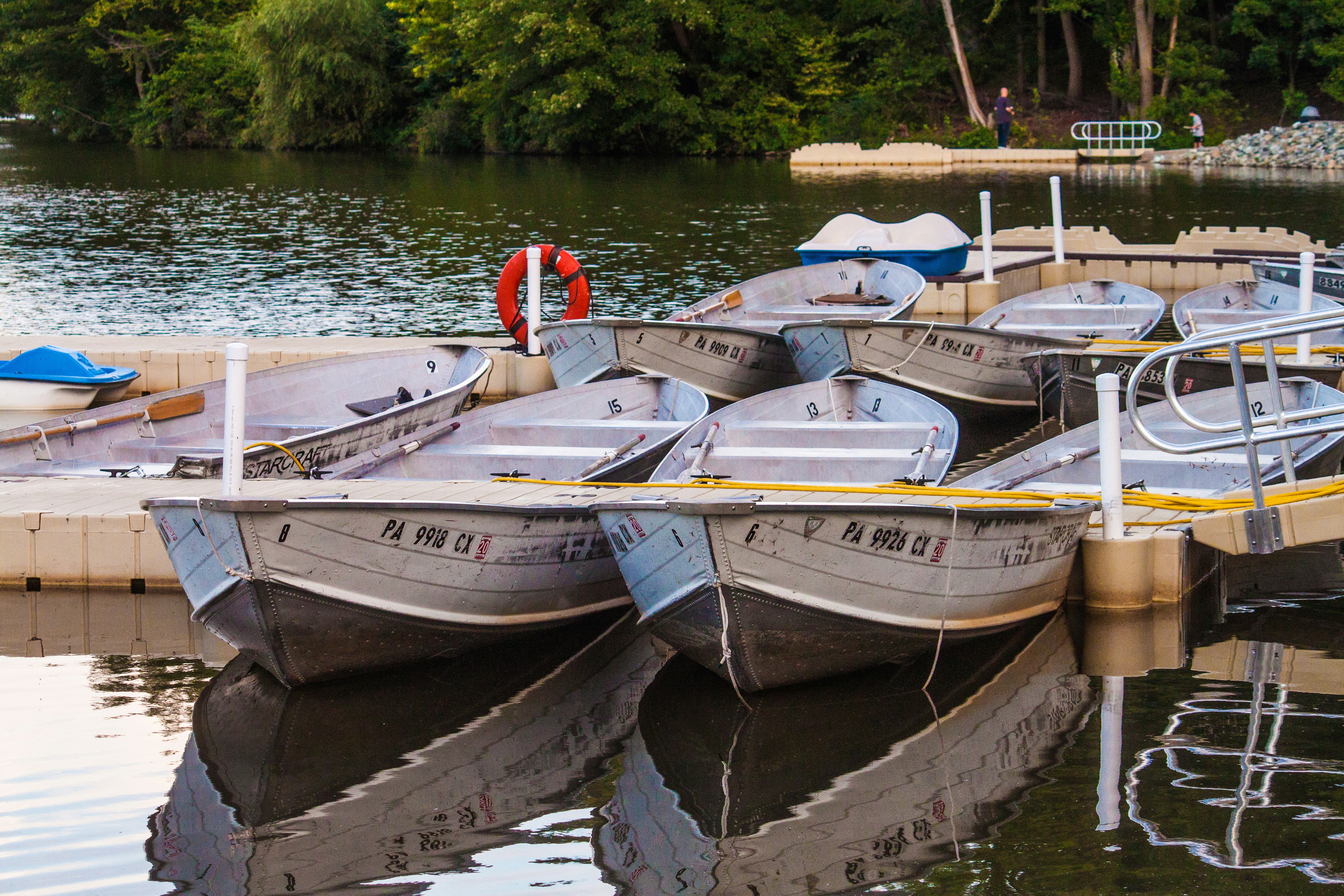 Several small boats docked on a calm lake.